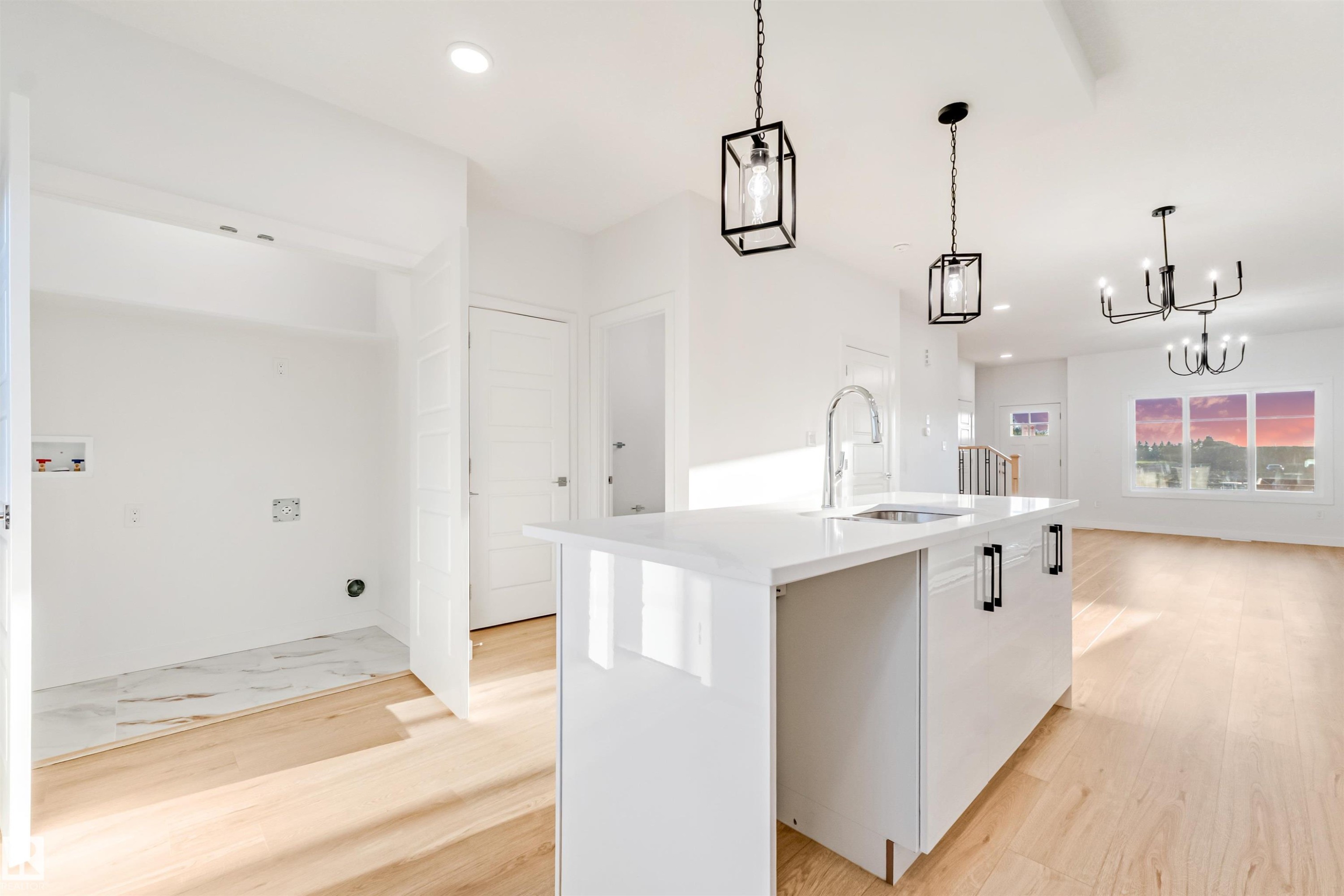 Modern kitchen island with a built-in sink and contemporary pendant lighting - 1511 211 Street Nw, Edmonton, AB