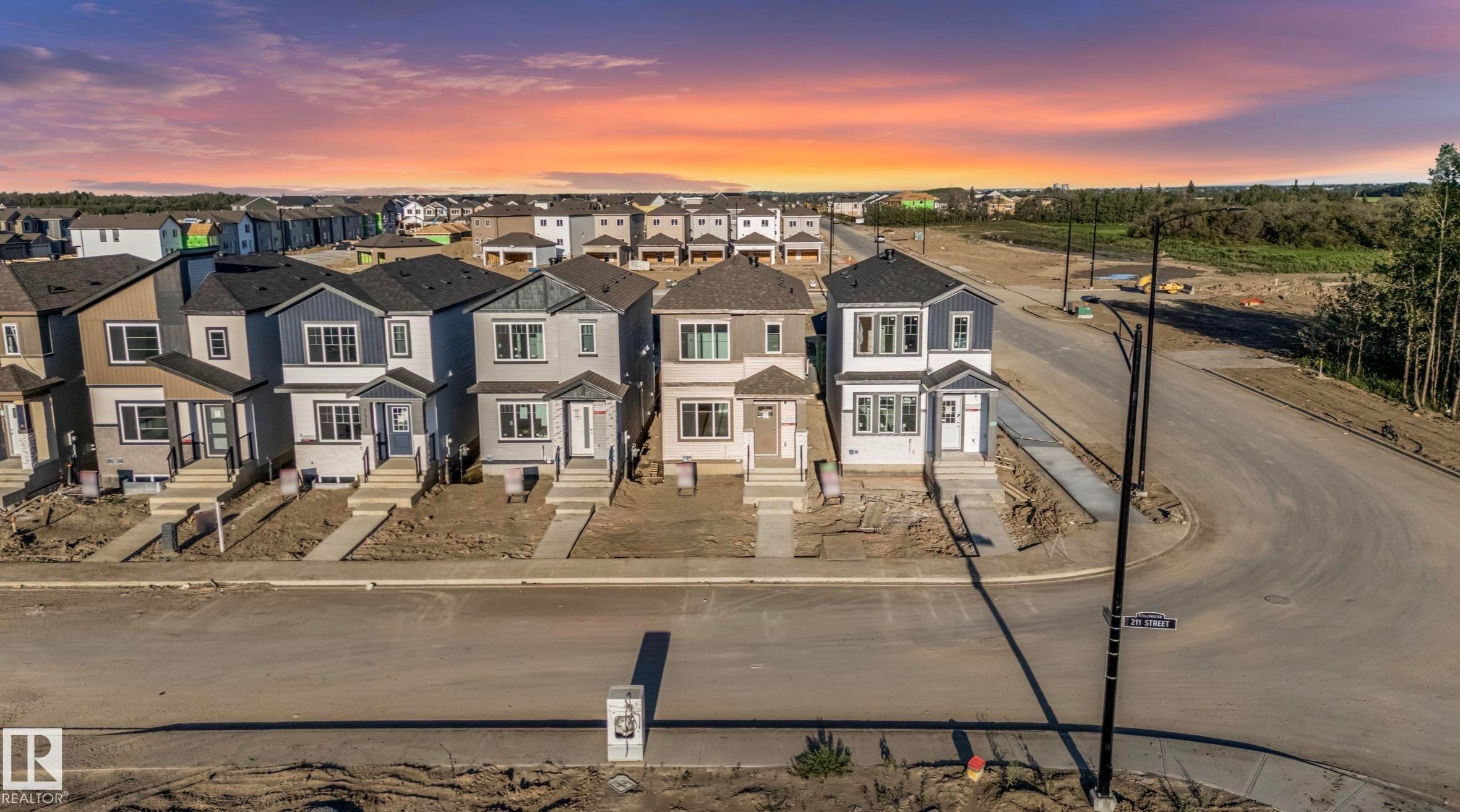 Newly constructed homes featuring modern architectural designs, varied exterior finishes, and concrete sidewalks - 1511 211 Street Nw, Edmonton, AB