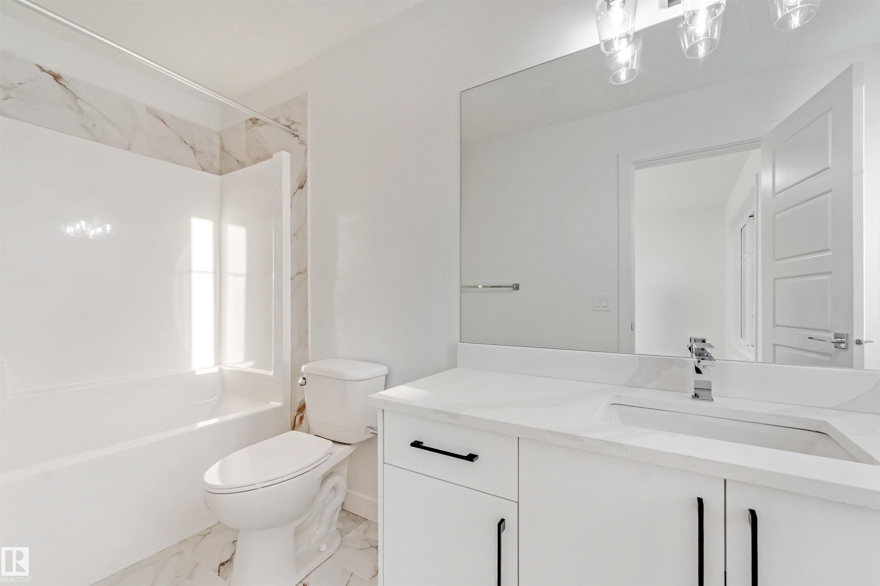 White vanity with a rectangular undermount sink, a chrome faucet, and black hardware - 1511 211 Street Nw, Edmonton, AB