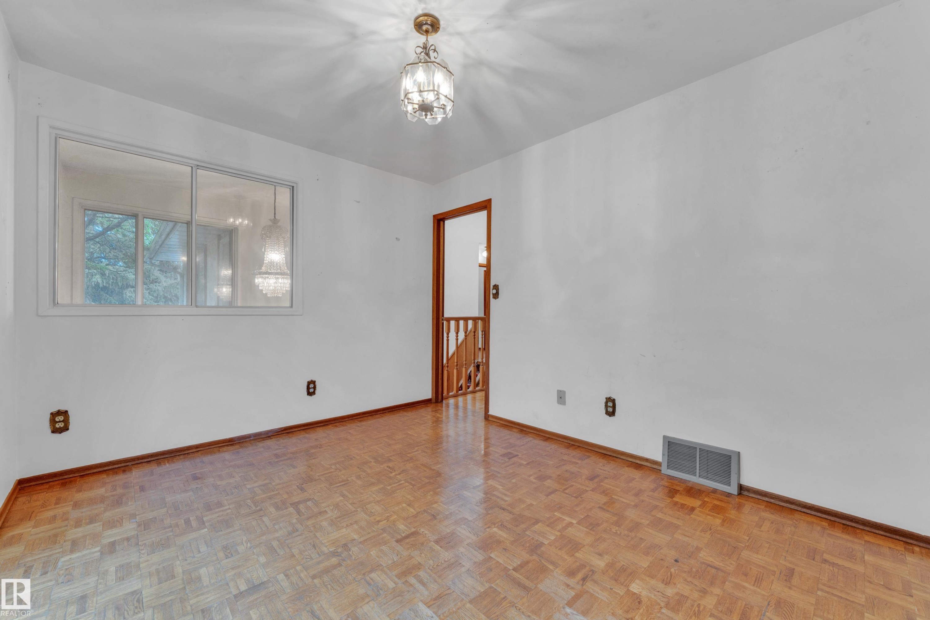 Room featuring parquet wood-finish flooring and white walls - 10819 54 Avenue, Edmonton, AB
