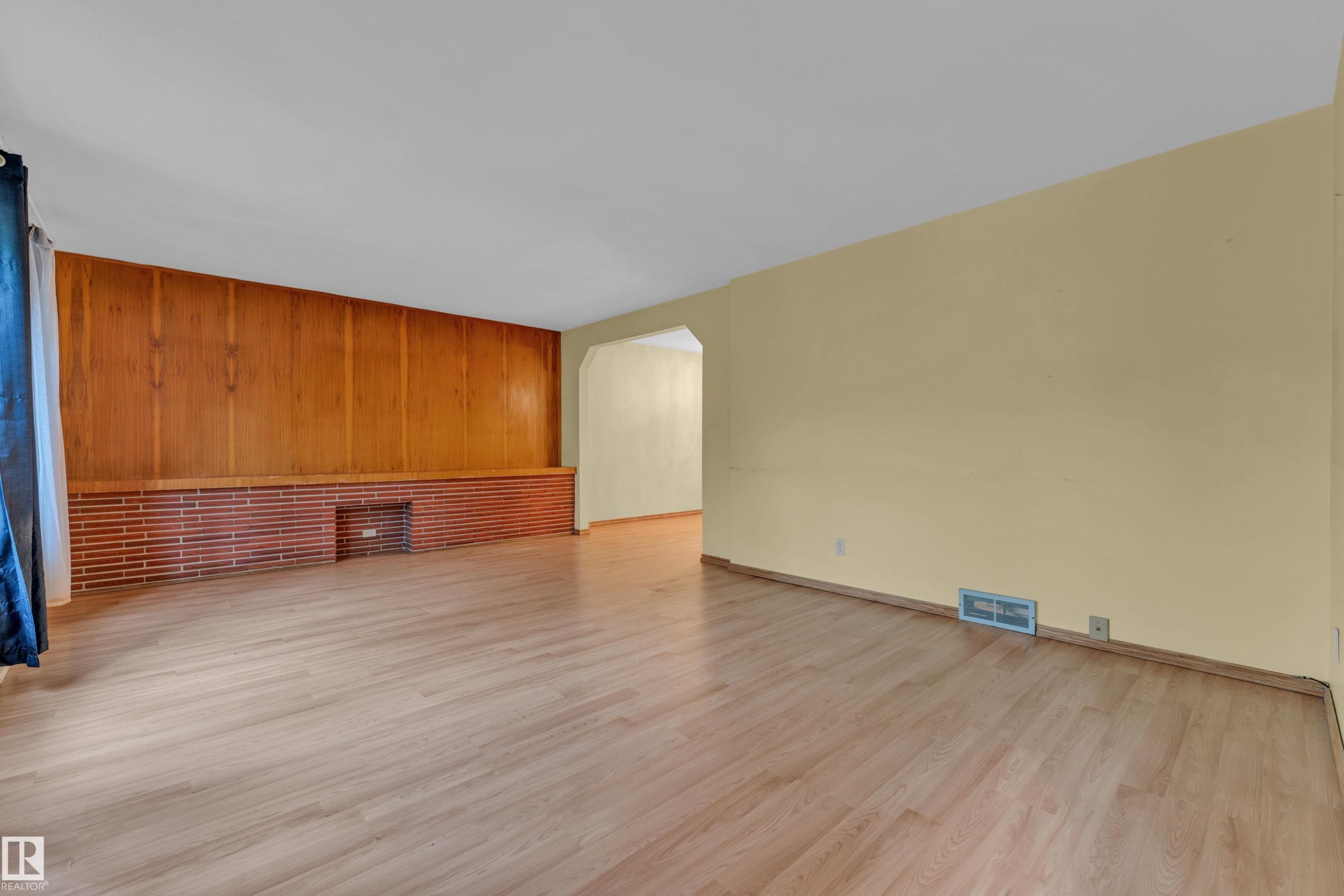Living area featuring light wood-finish flooring and light yellow walls - 10819 54 Avenue, Edmonton, AB
