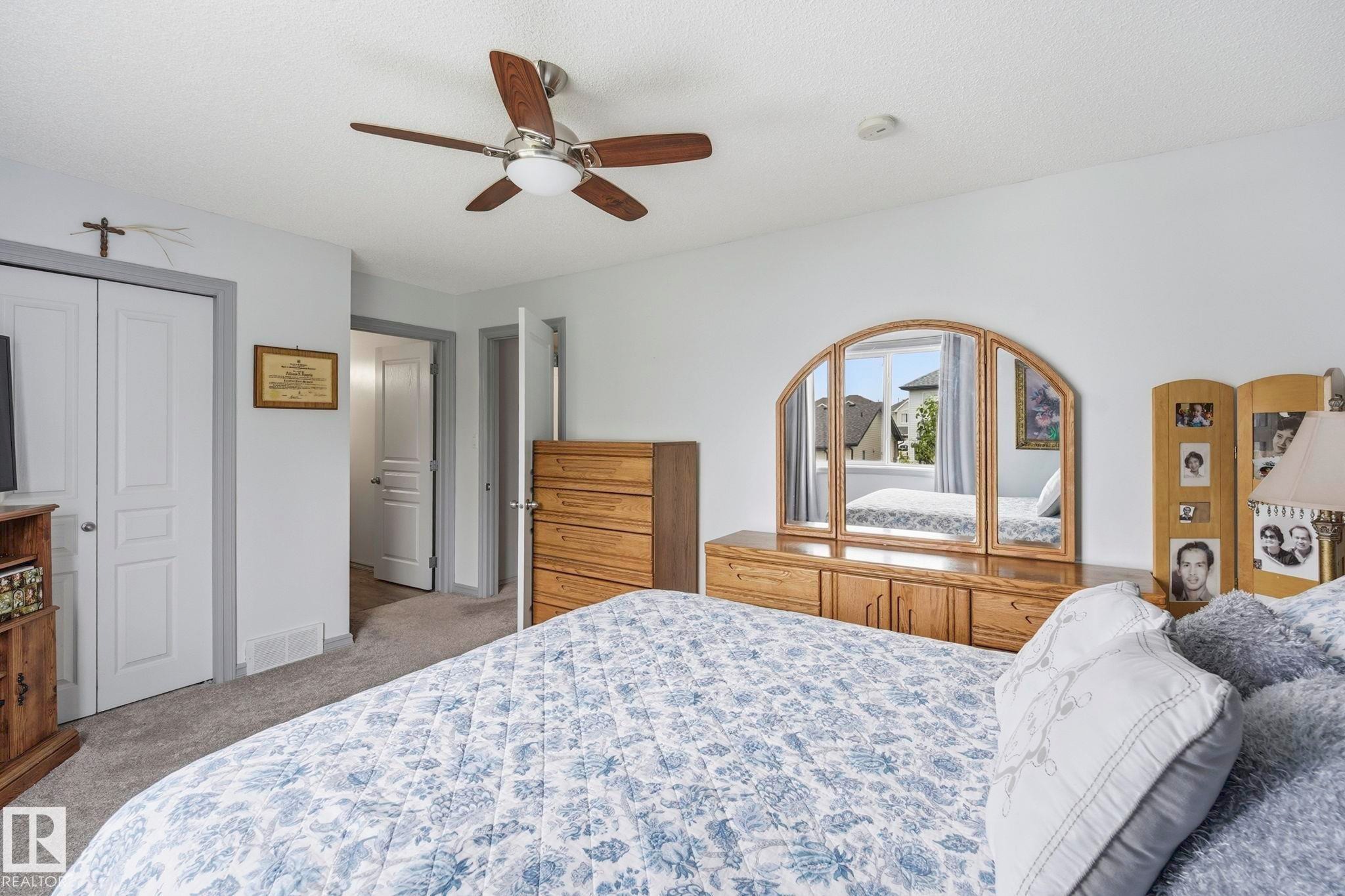 Ceiling fan with wooden blades, neutral wall paint, and gray carpeting - 3231 28A Avenue Nw, Edmonton, AB - Indoor Photo Showing Bedroom