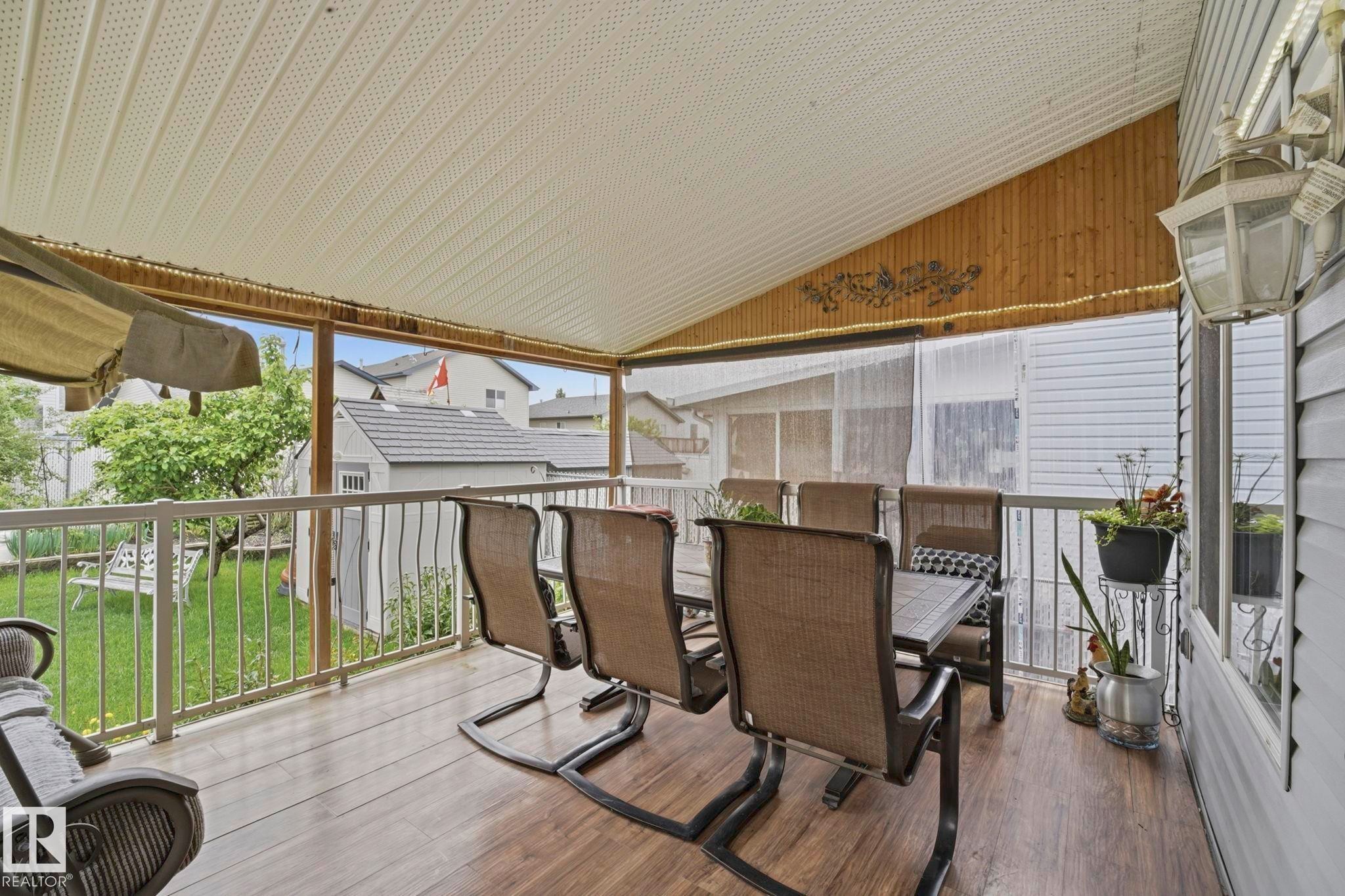 Covered outdoor deck with wood-finish flooring - 3231 28A Avenue Nw, Edmonton, AB - Outdoor With Deck Patio Veranda With Exterior