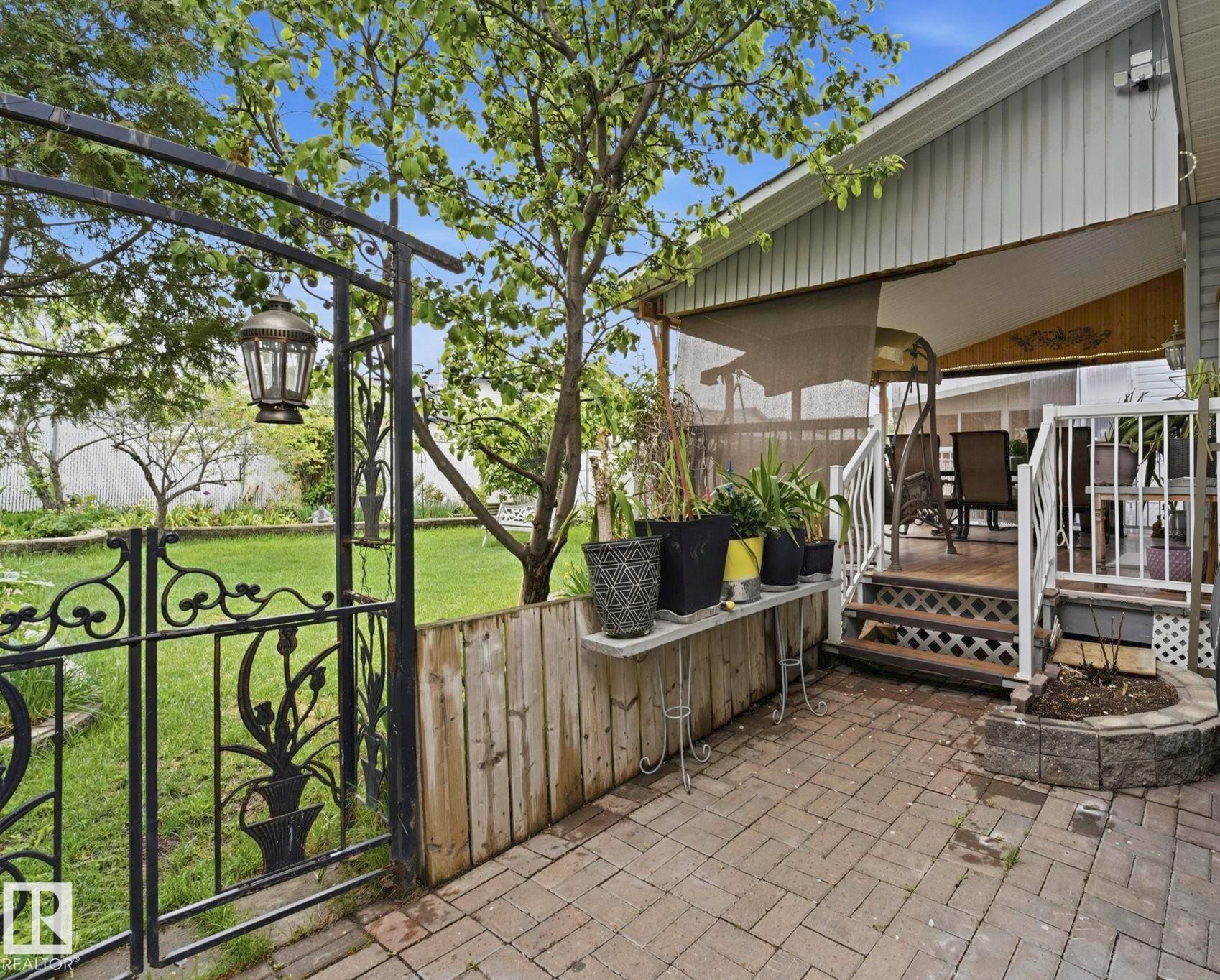 Brick paver patio with a stone-edged garden bed - 3231 28A Avenue Nw, Edmonton, AB - Outdoor With Deck Patio Veranda With Exterior