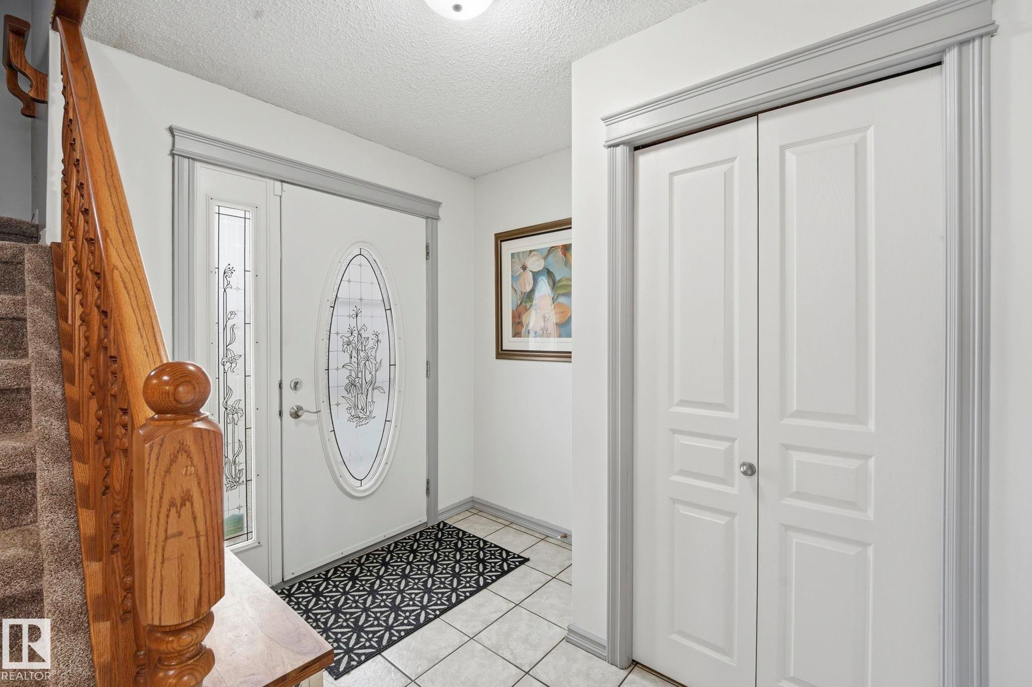 Entryway featuring a decorative glass front door, side panel, and ceramic tile flooring - 3231 28A Avenue Nw, Edmonton, AB - Indoor Photo Showing Other Room