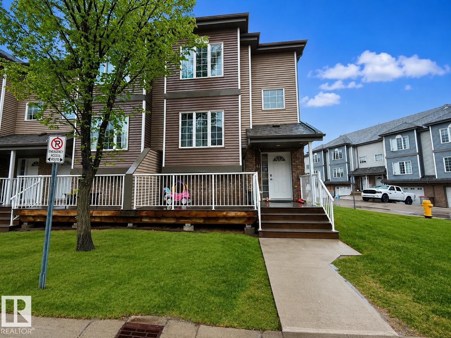 Townhome exterior featuring multi-toned siding, white trim, and a covered entryway - 41 5102 30 Avenue, Beaumont, AB
