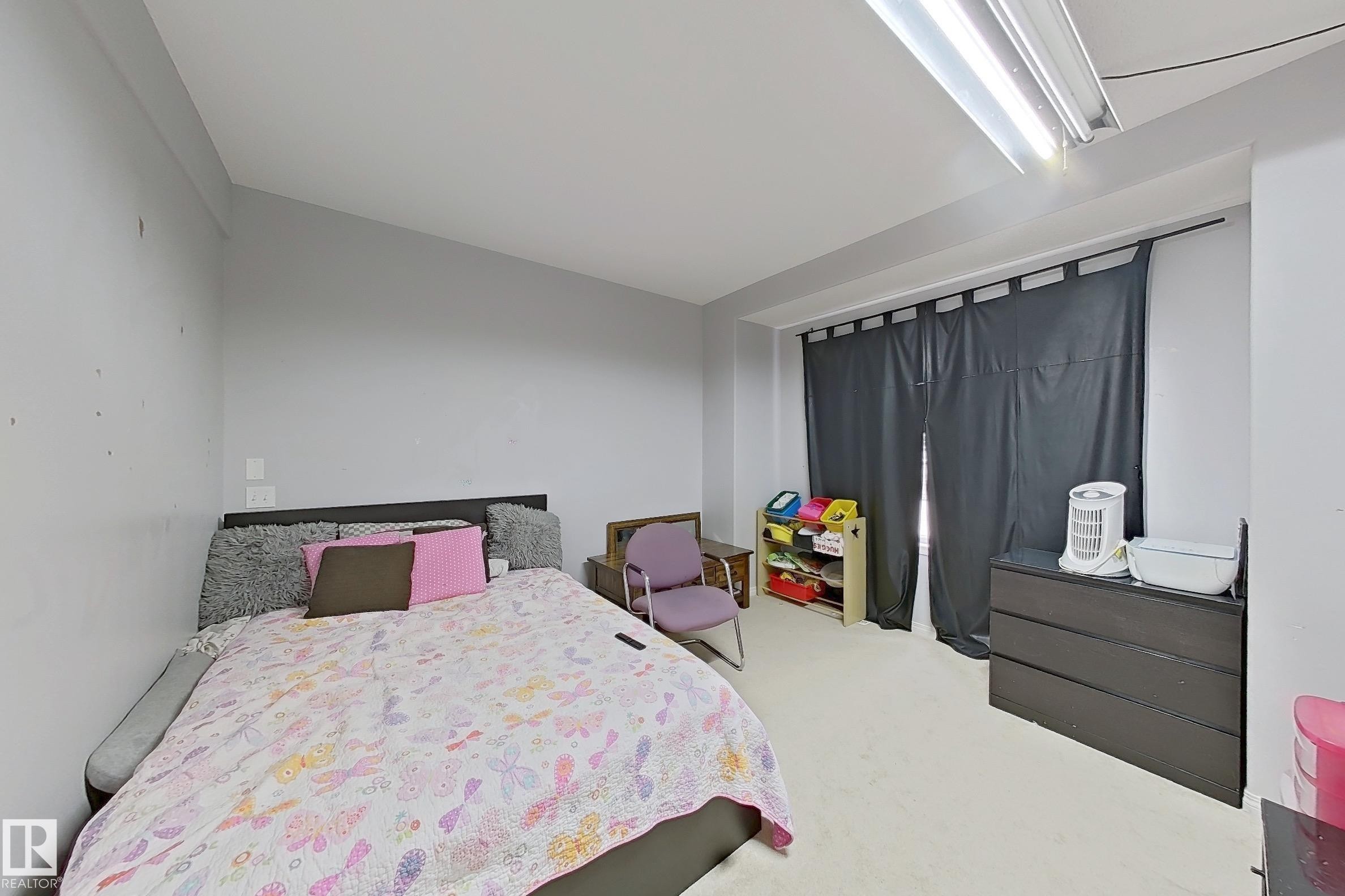 Spacious room featuring light gray walls, white ceiling, and light-colored carpeting - 41 5102 30 Avenue, Beaumont, AB