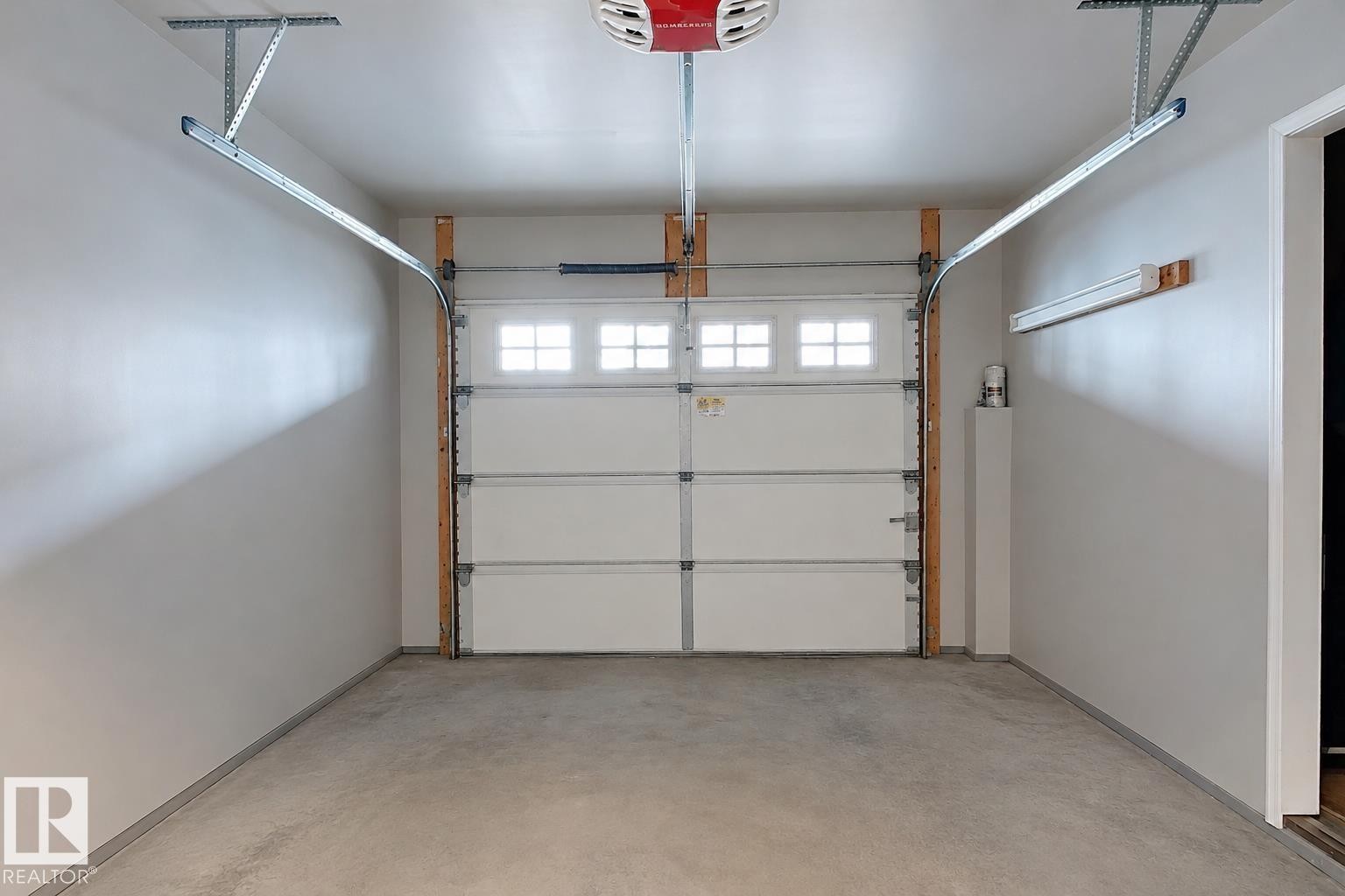 Finished garage interior with painted walls and a concrete floor - 41 5102 30 Avenue, Beaumont, AB