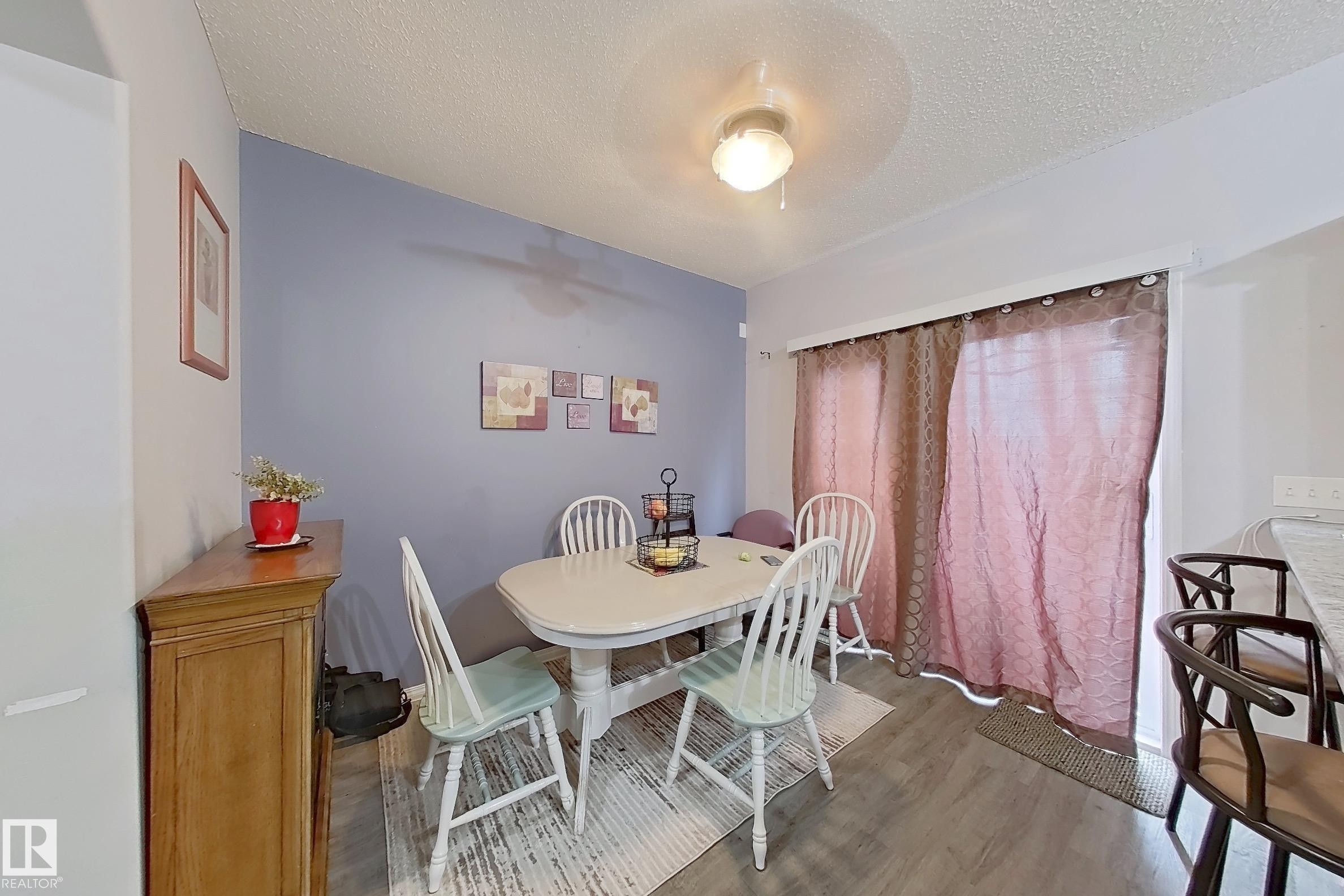 Dining area featuring wood-finish flooring and a light fixture - 41 5102 30 Avenue, Beaumont, AB