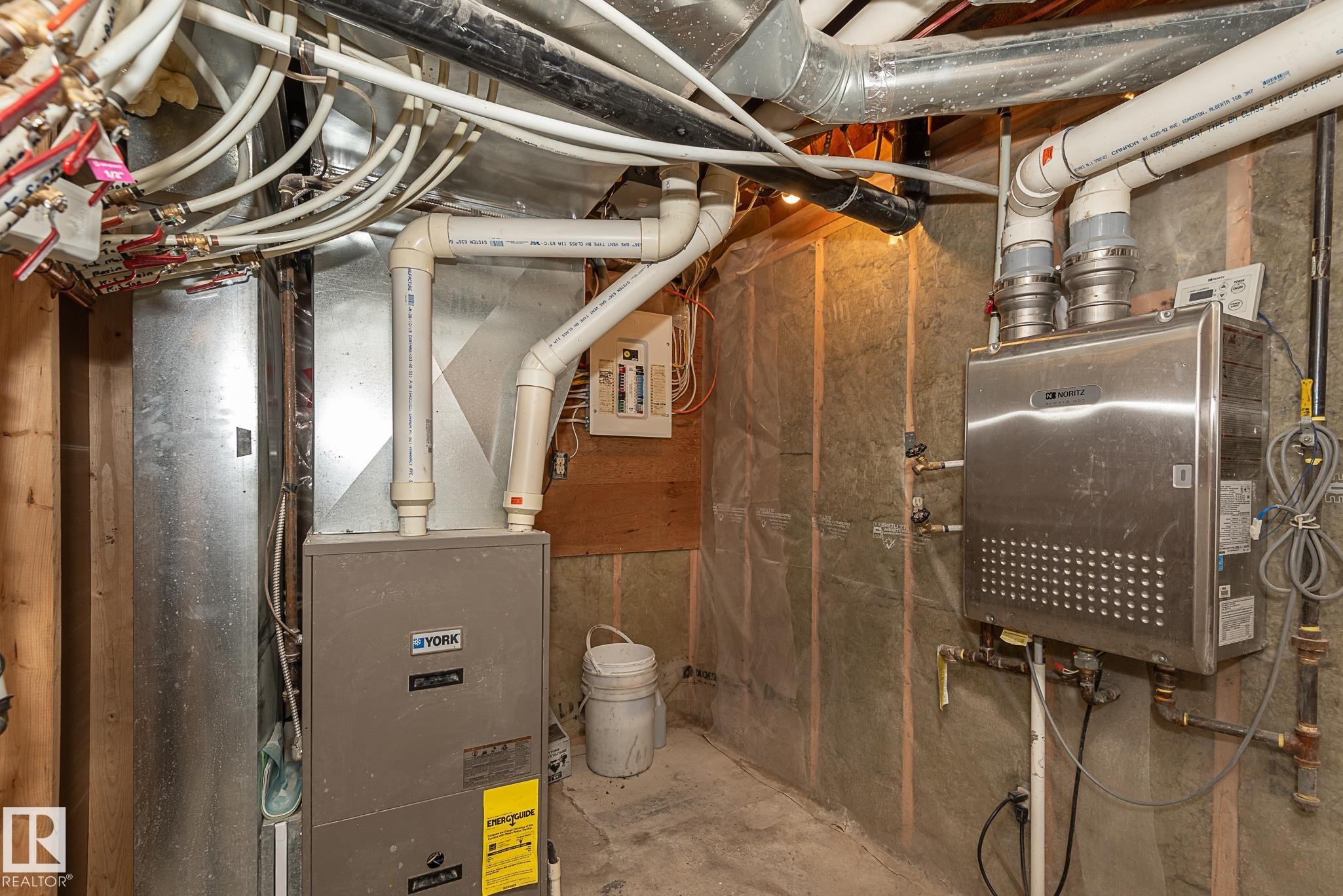 Utility space featuring a forced air furnace, tankless water heater, exposed ductwork, and PEX plumbing - 9623 110A Avenue, Edmonton, AB