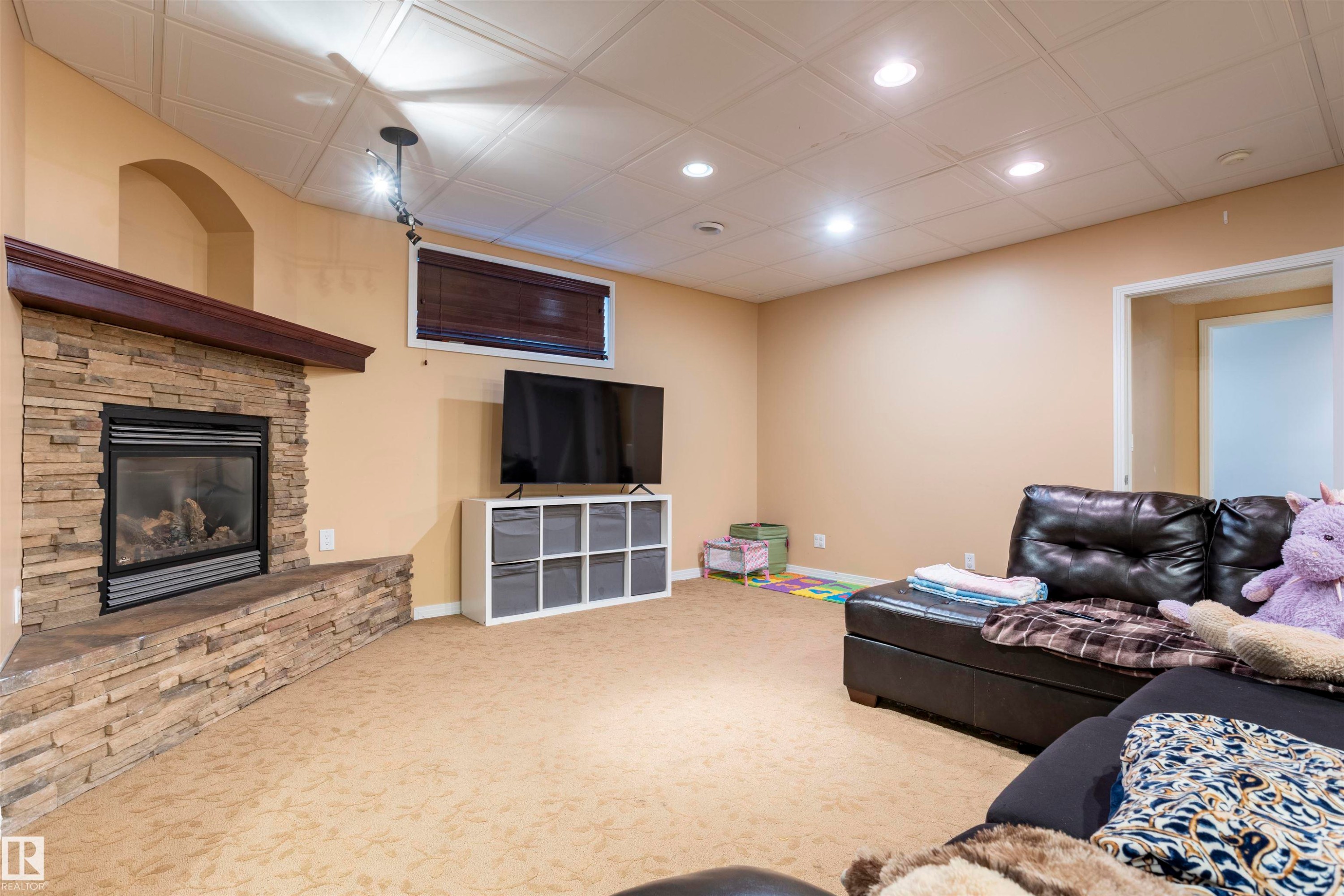 Stone-clad fireplace with a wood mantel - 1441 Highwood Boulevard, Devon, AB