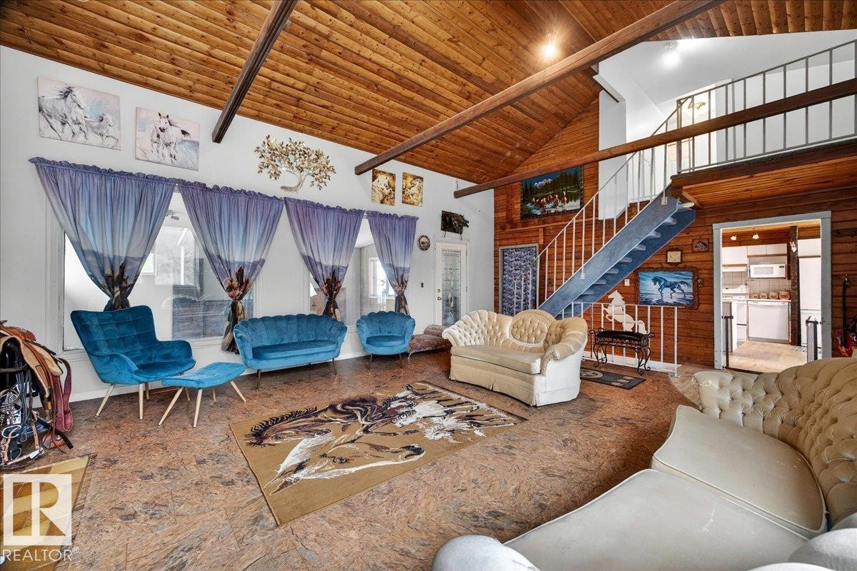 Vaulted wood-paneled ceilings with exposed beams, open loft area, and an exposed wood wall - 140 50047 Rge Rd 244, Rural Leduc County, AB