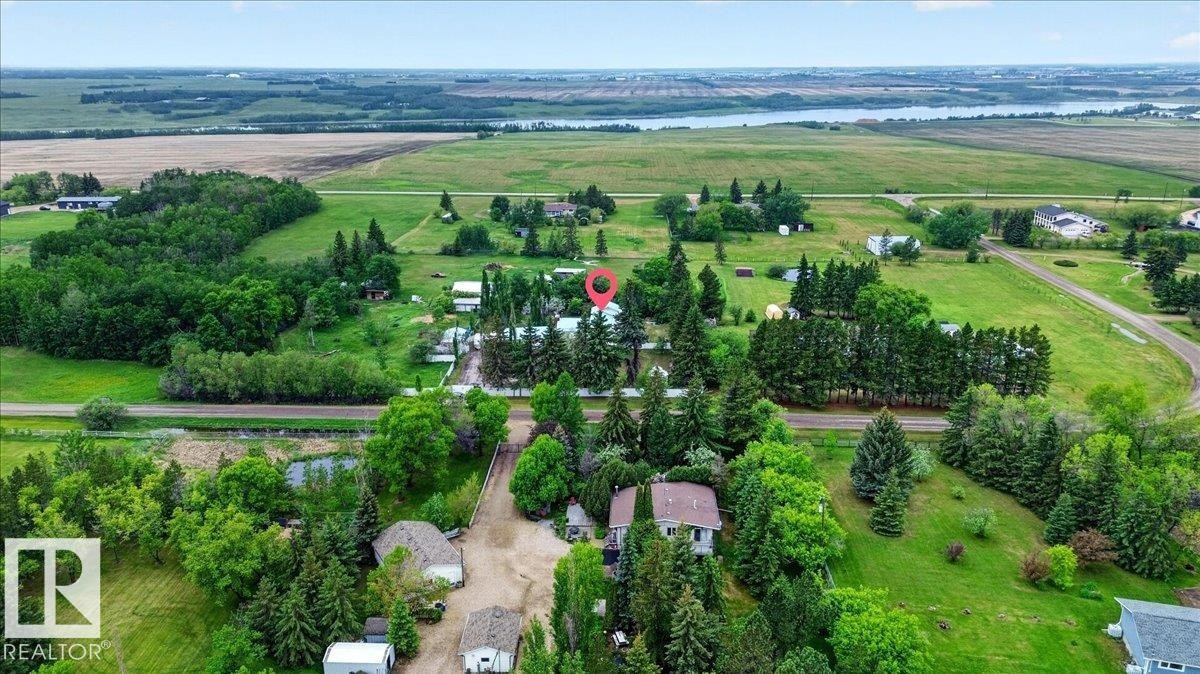 Expansive parcel featuring a main residence, mature tree coverage, and a gravel drive - 140 50047 Rge Rd 244, Rural Leduc County, AB