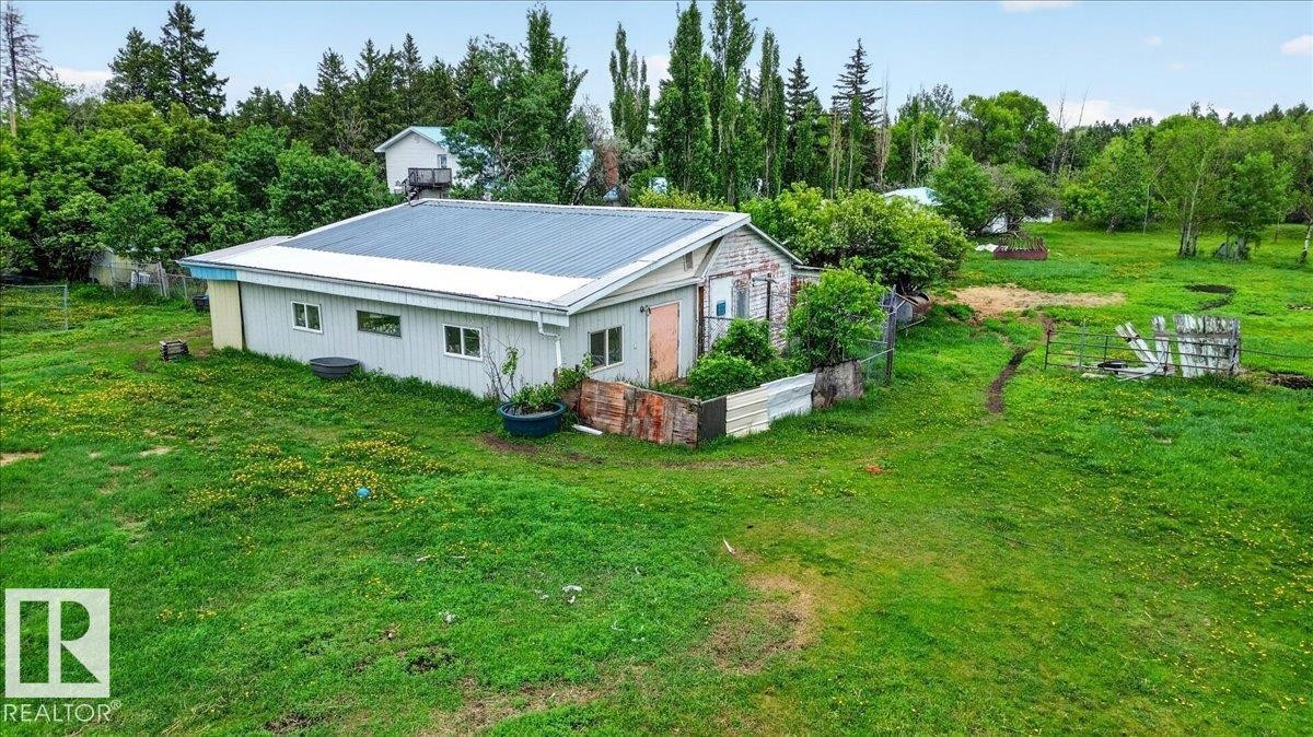 Single-story structure featuring light-colored siding and a corrugated metal roof - 140 50047 Rge Rd 244, Rural Leduc County, AB