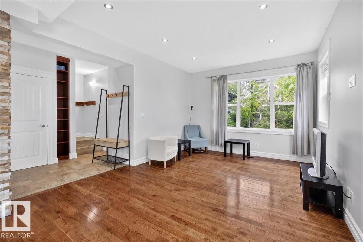 Hardwood flooring extends through this bright living area with recessed lighting - 10958 88 Avenue, Edmonton, AB