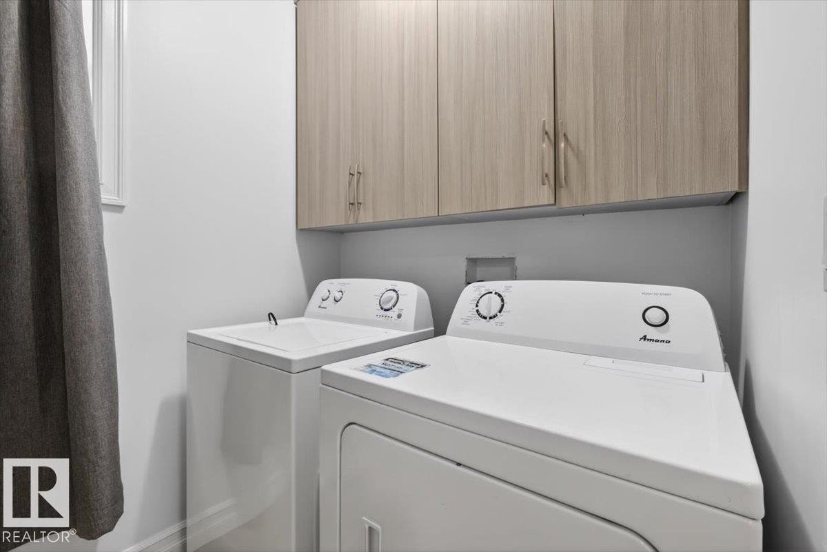 Dedicated laundry area with light wood-finish cabinetry - 10958 88 Avenue, Edmonton, AB