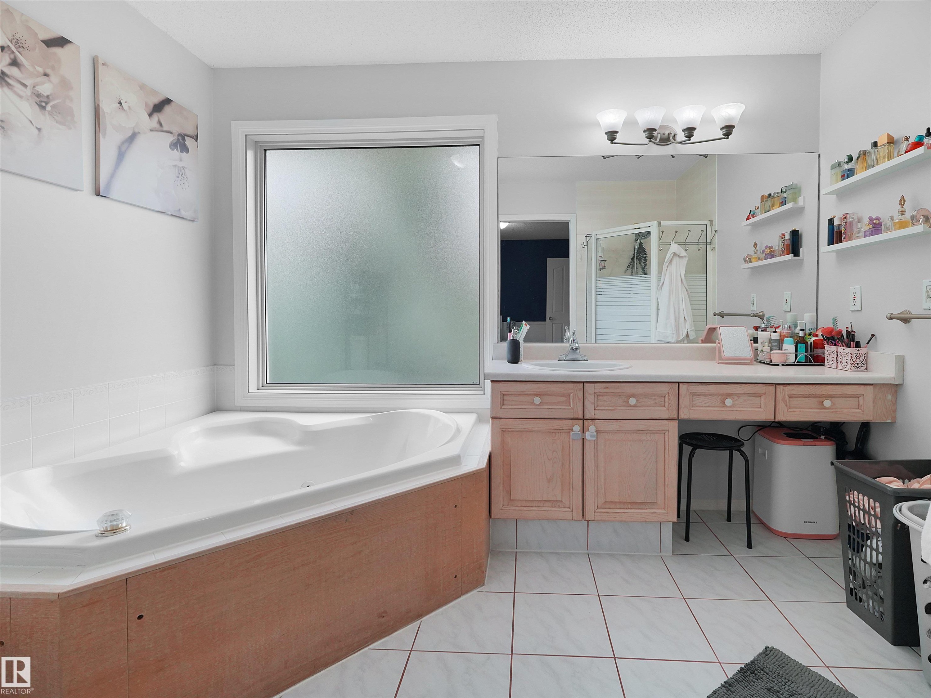 Soaking tub with a wood-finish surround, complemented by a large frosted window - 208 Ferguson Place, Edmonton, AB