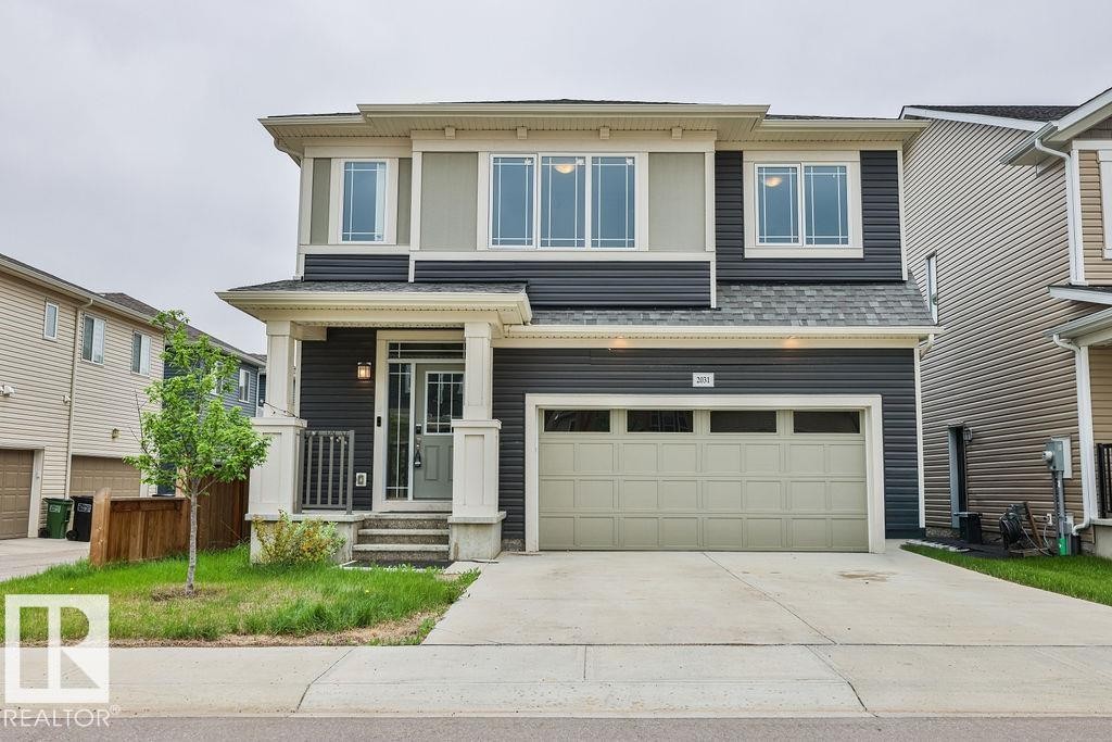 Two-story residential exterior featuring dark gray siding and light beige trim - 2031 207 Street, Edmonton, AB