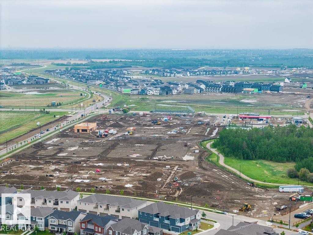 Developing residential area featuring established homes, active construction sites, and infrastructure development - 2031 207 Street, Edmonton, AB