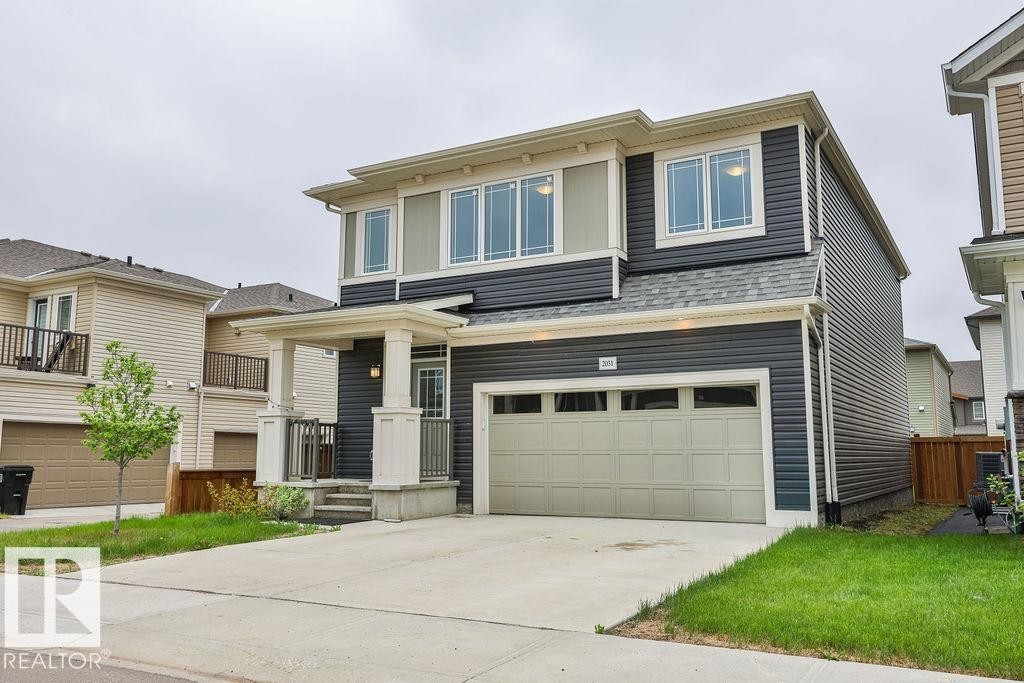 Two-story residence featuring dark gray horizontal siding and contrasting light trim - 2031 207 Street, Edmonton, AB