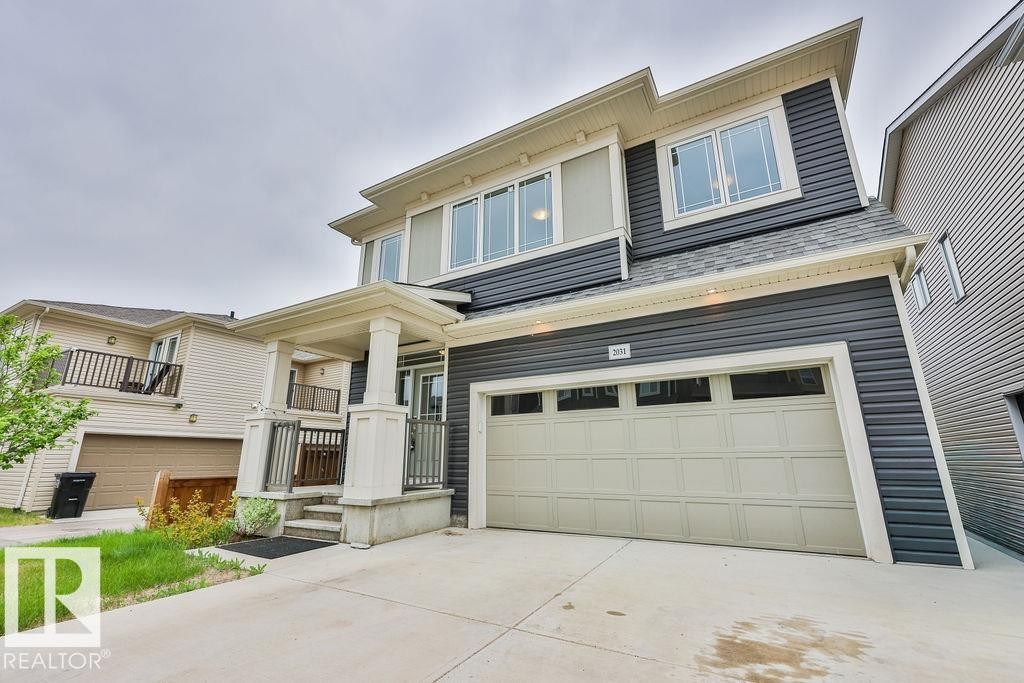 Contemporary two-story residence featuring dark gray horizontal siding and light trim - 2031 207 Street, Edmonton, AB