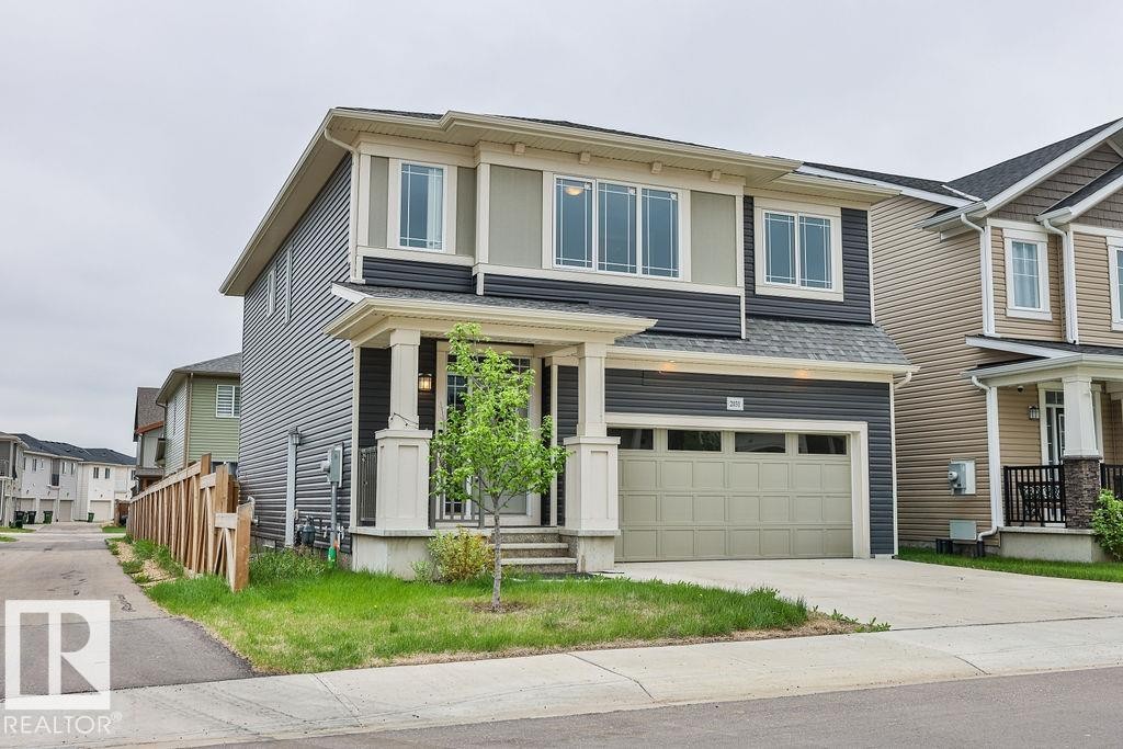 Two-story residence featuring a two-tone facade, an integrated garage, and a covered front entry with columns - 2031 207 Street, Edmonton, AB
