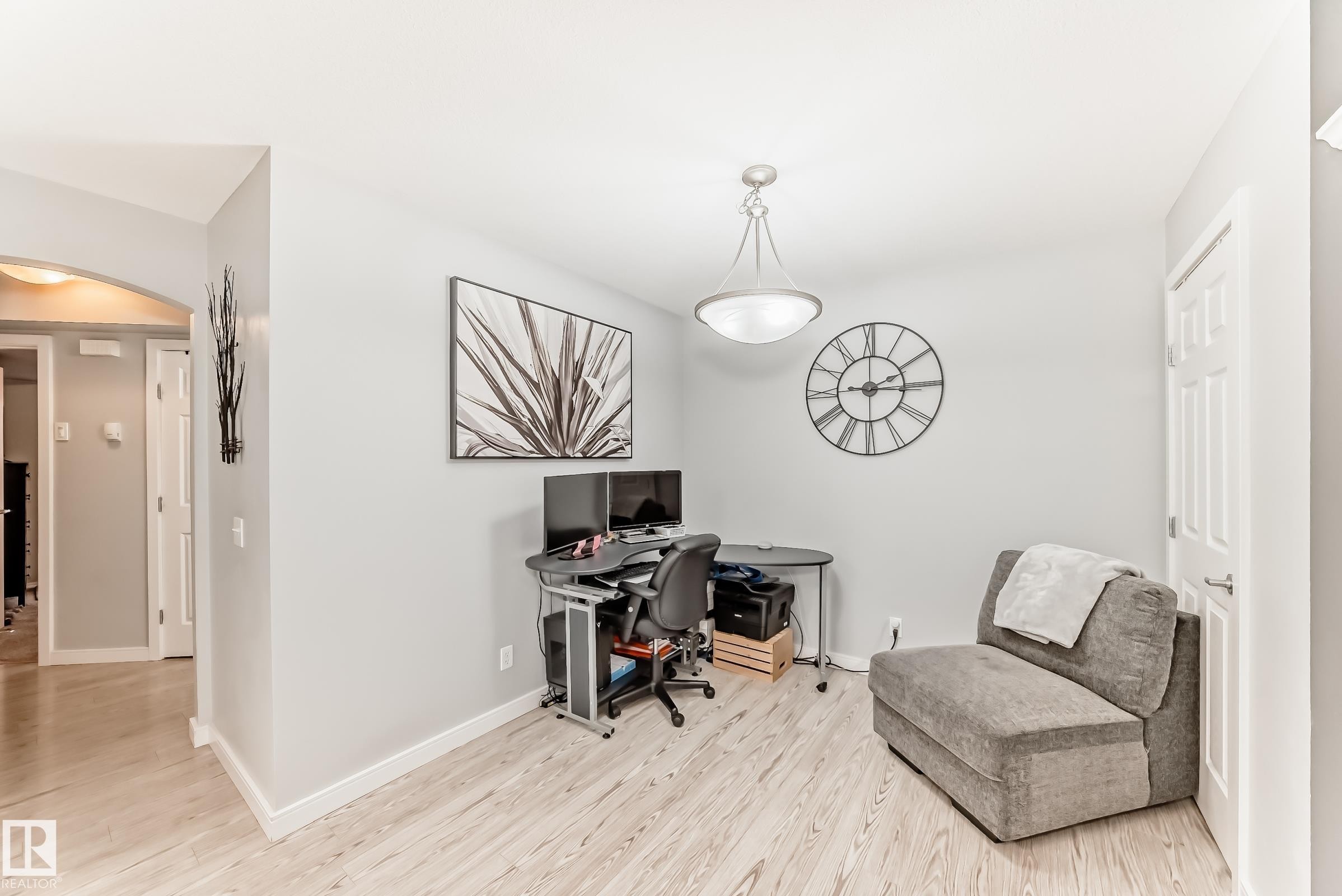 Light wood-finish flooring throughout, complemented by a contemporary semi-flush mount ceiling fixture - 53 150 Edwards Drive, Edmonton, AB