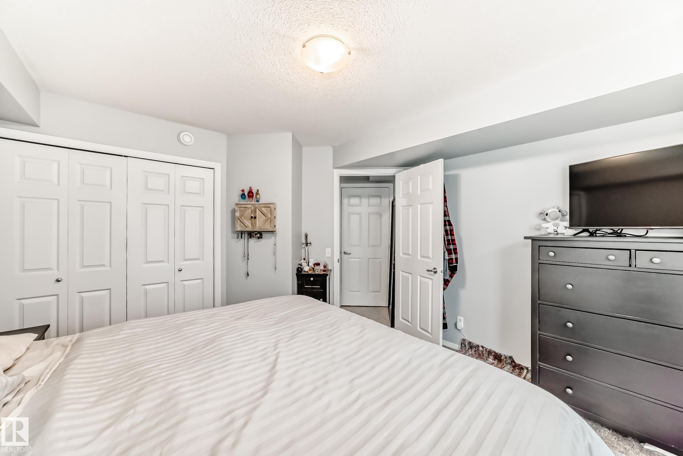 Recessed ceiling light fixture illuminating a room with light gray walls and white trim - 53 150 Edwards Drive, Edmonton, AB