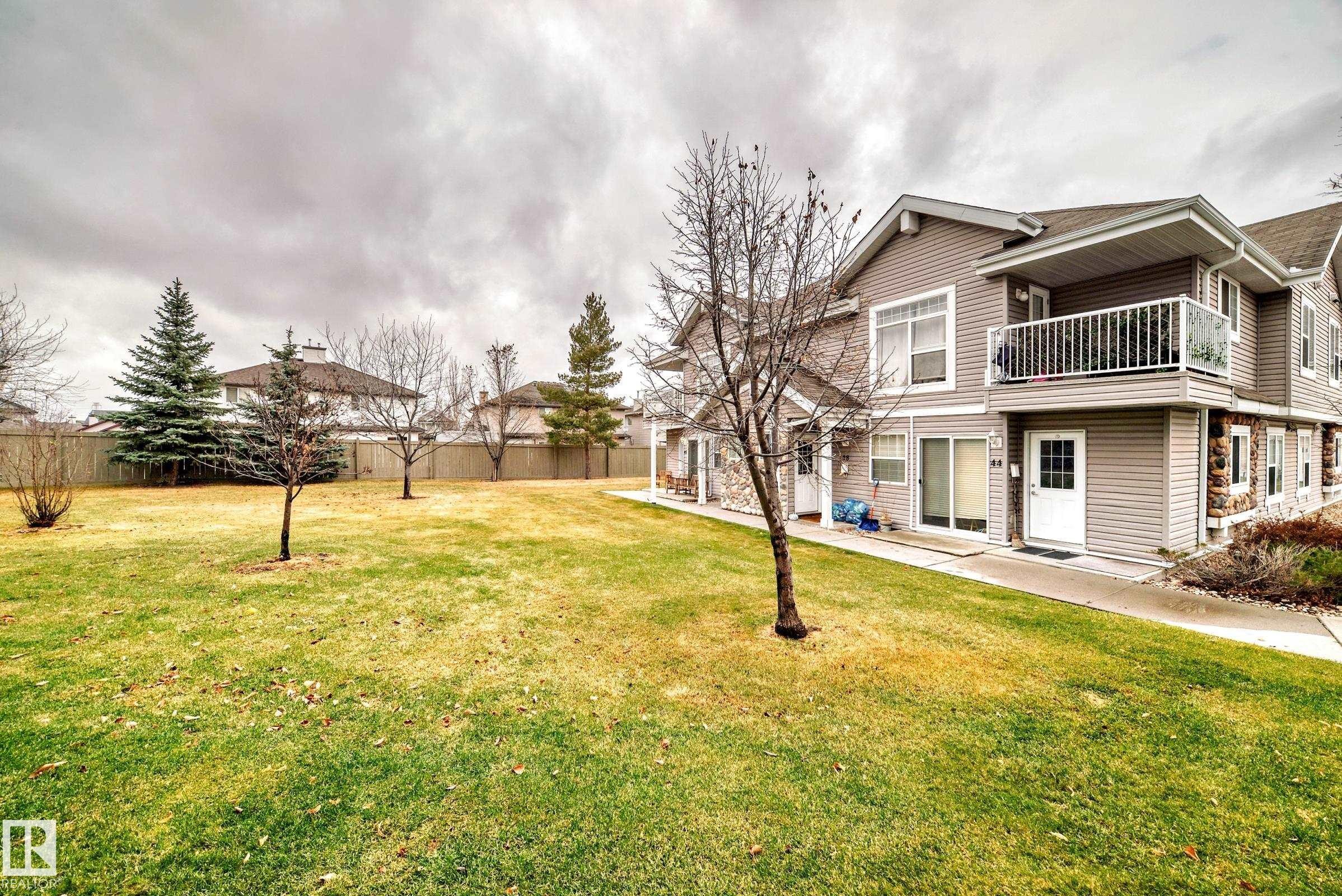 Multi-level residential building featuring horizontal siding and stone veneer accents - 53 150 Edwards Drive, Edmonton, AB
