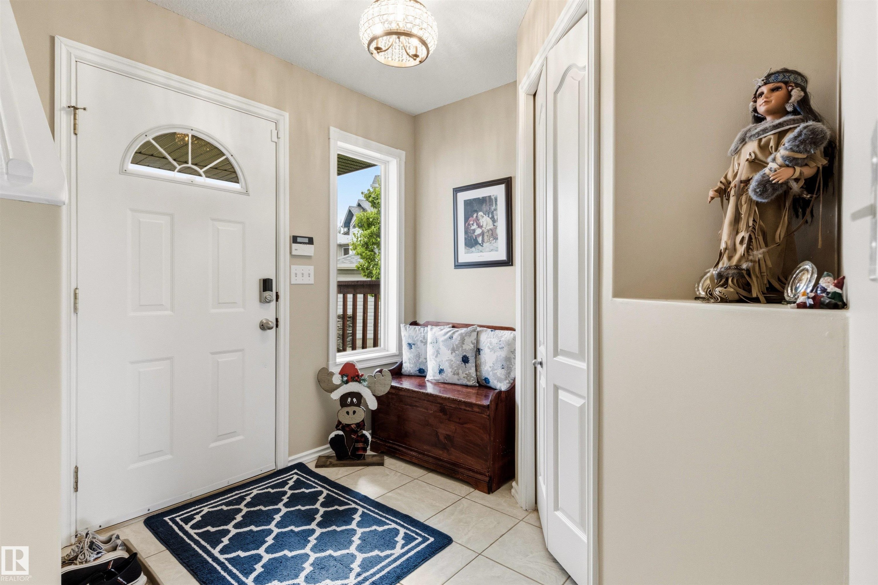 Entryway featuring a white paneled door with an arched transom, a side window, and light tile flooring - 32 Lamplight Bay, Spruce Grove, AB