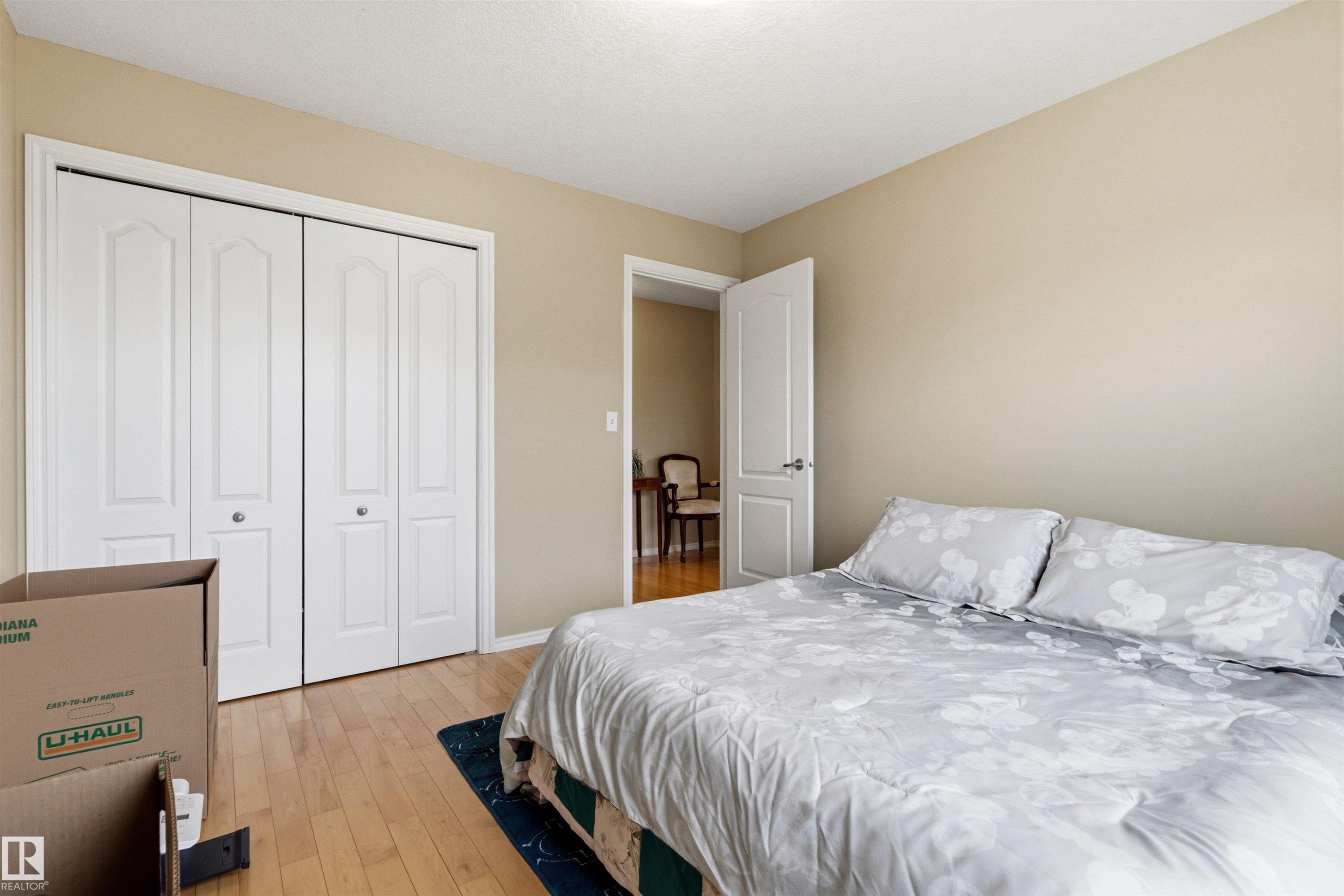 Room featuring wood-finish flooring, neutral wall tones, and white trim - 32 Lamplight Bay, Spruce Grove, AB