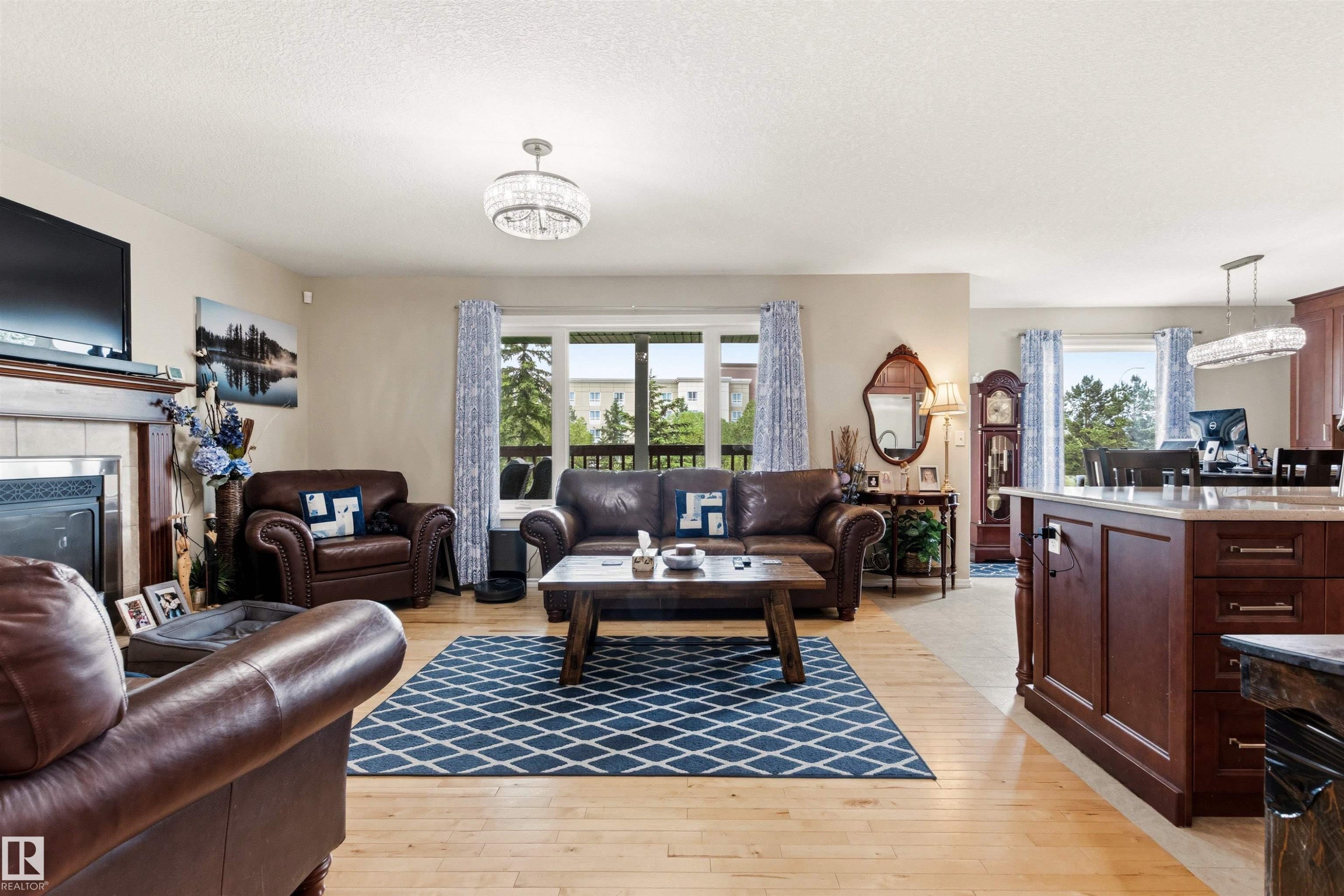Bright open-concept living area featuring light wood-finish flooring and neutral wall tones - 32 Lamplight Bay, Spruce Grove, AB