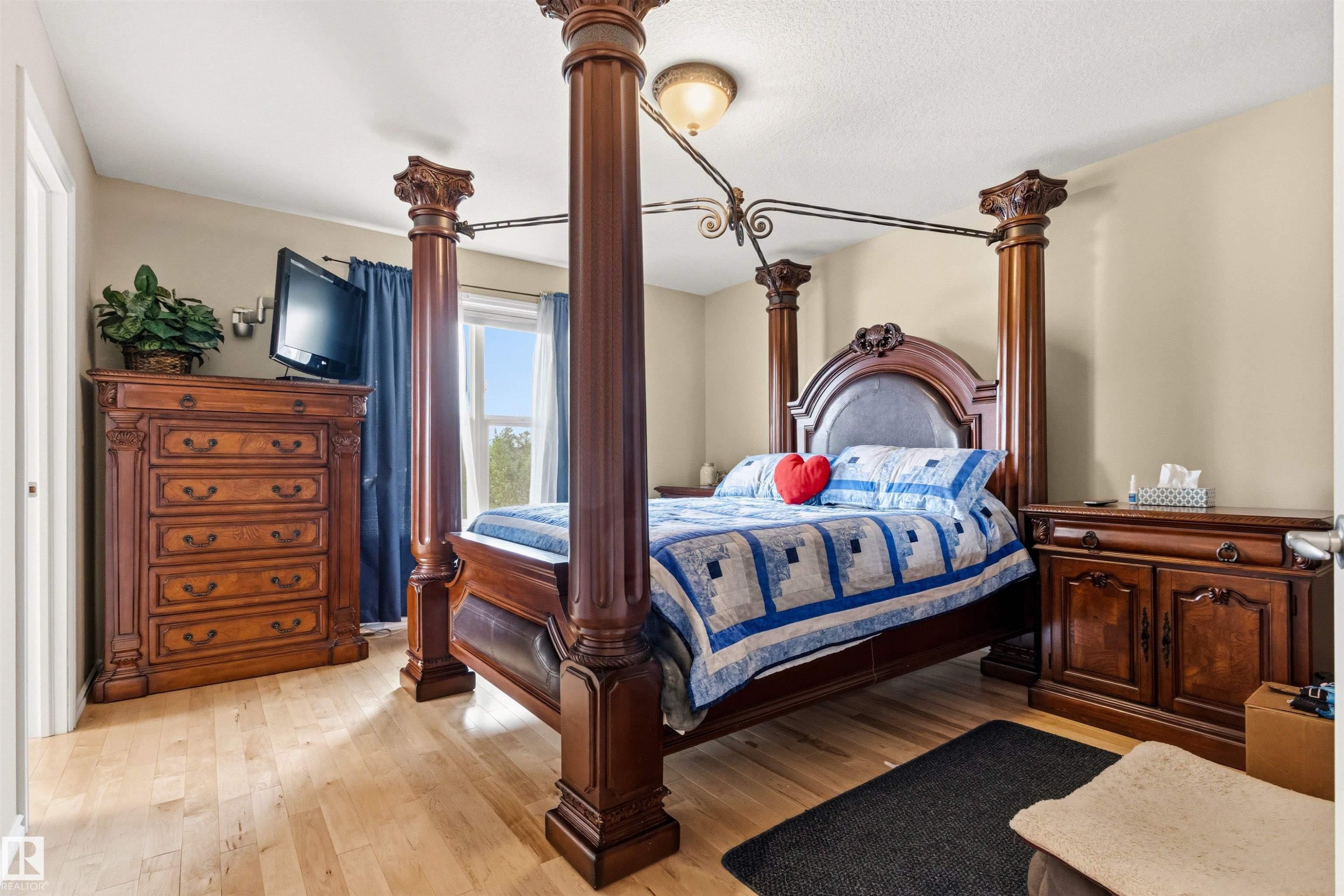 Bedroom featuring wood-finish flooring, a semi-flush mount ceiling light, and light-toned walls - 32 Lamplight Bay, Spruce Grove, AB
