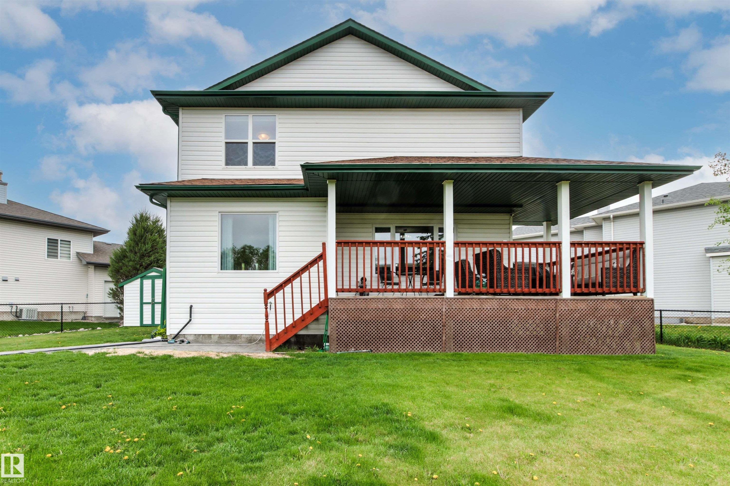 Rear exterior featuring white vinyl siding and a dark green roof - 32 Lamplight Bay, Spruce Grove, AB