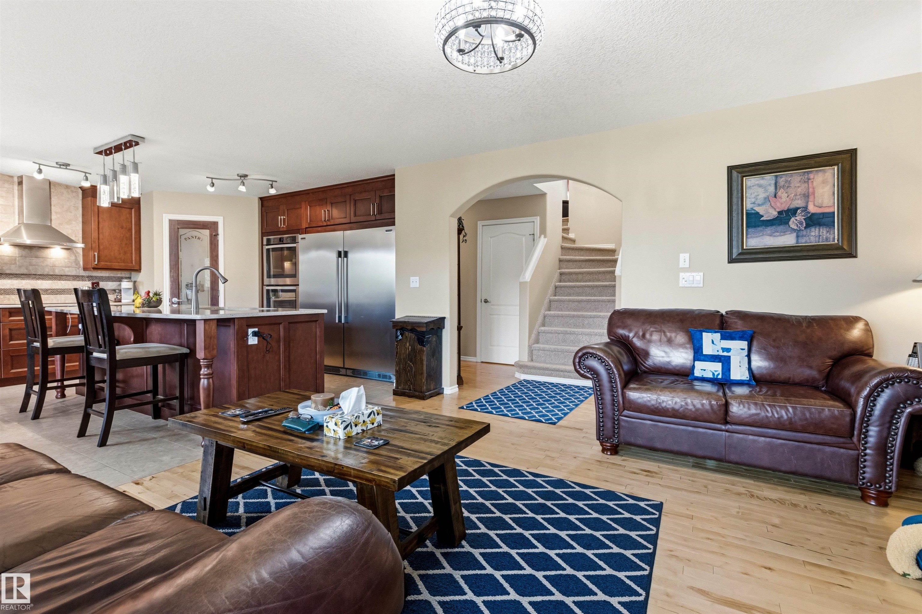 Kitchen and living area featuring wood-finish flooring - 32 Lamplight Bay, Spruce Grove, AB