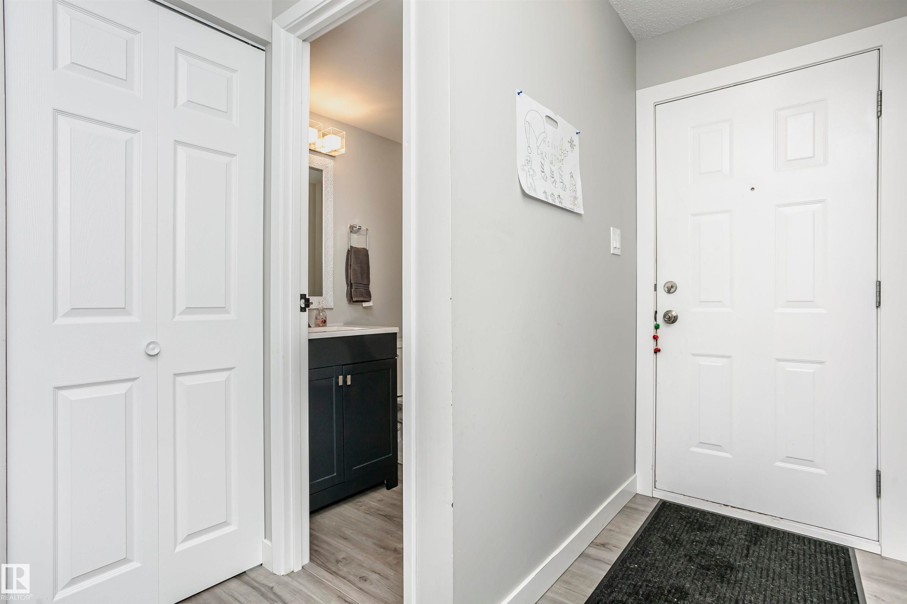 Entryway featuring a panel door, light gray wall tones, and wood-finish flooring - 3103 109 Street, Edmonton, AB