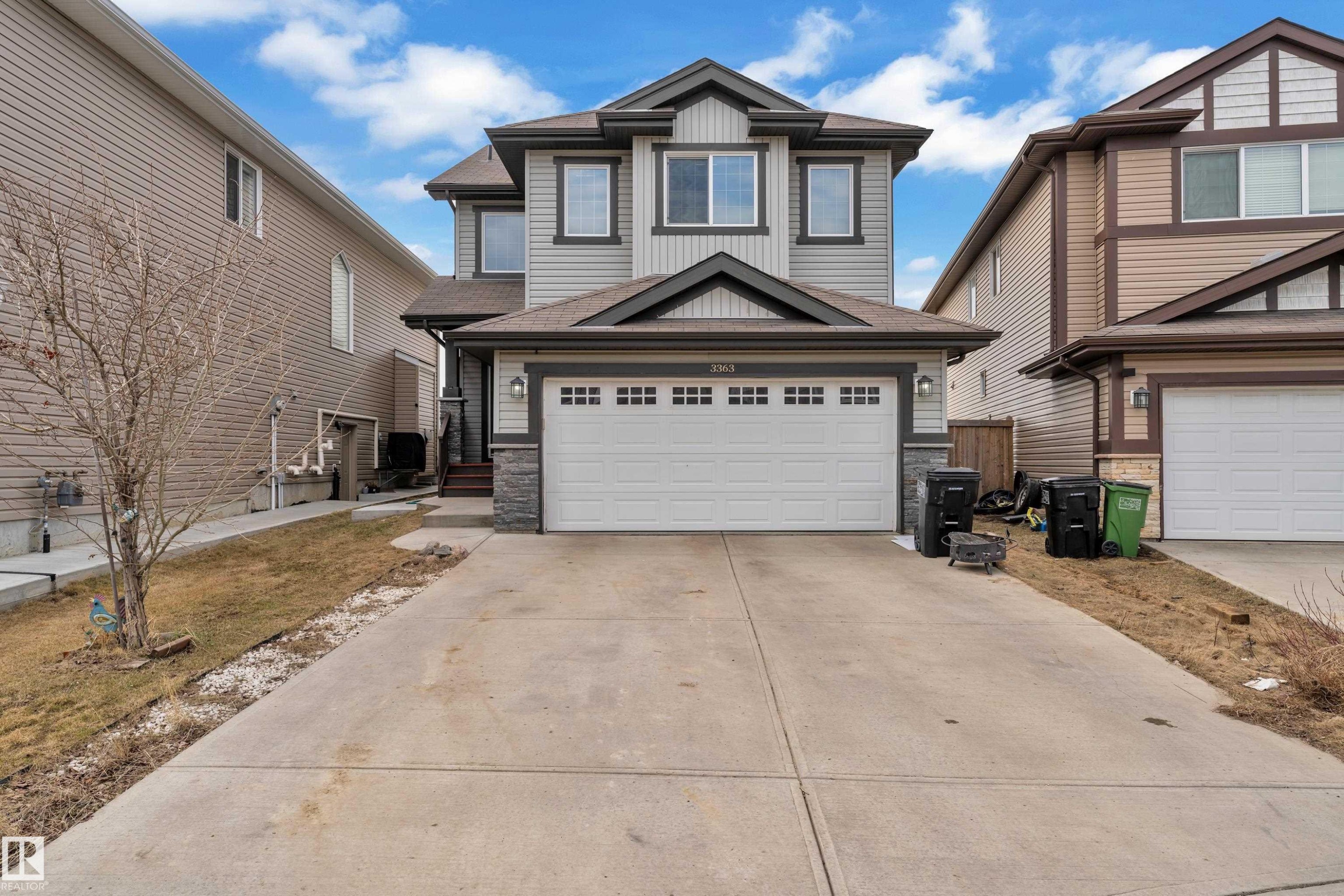 Two-story residence featuring a dual-tone exterior with light siding and dark trim accents - 3363 13 Ave, Edmonton, AB