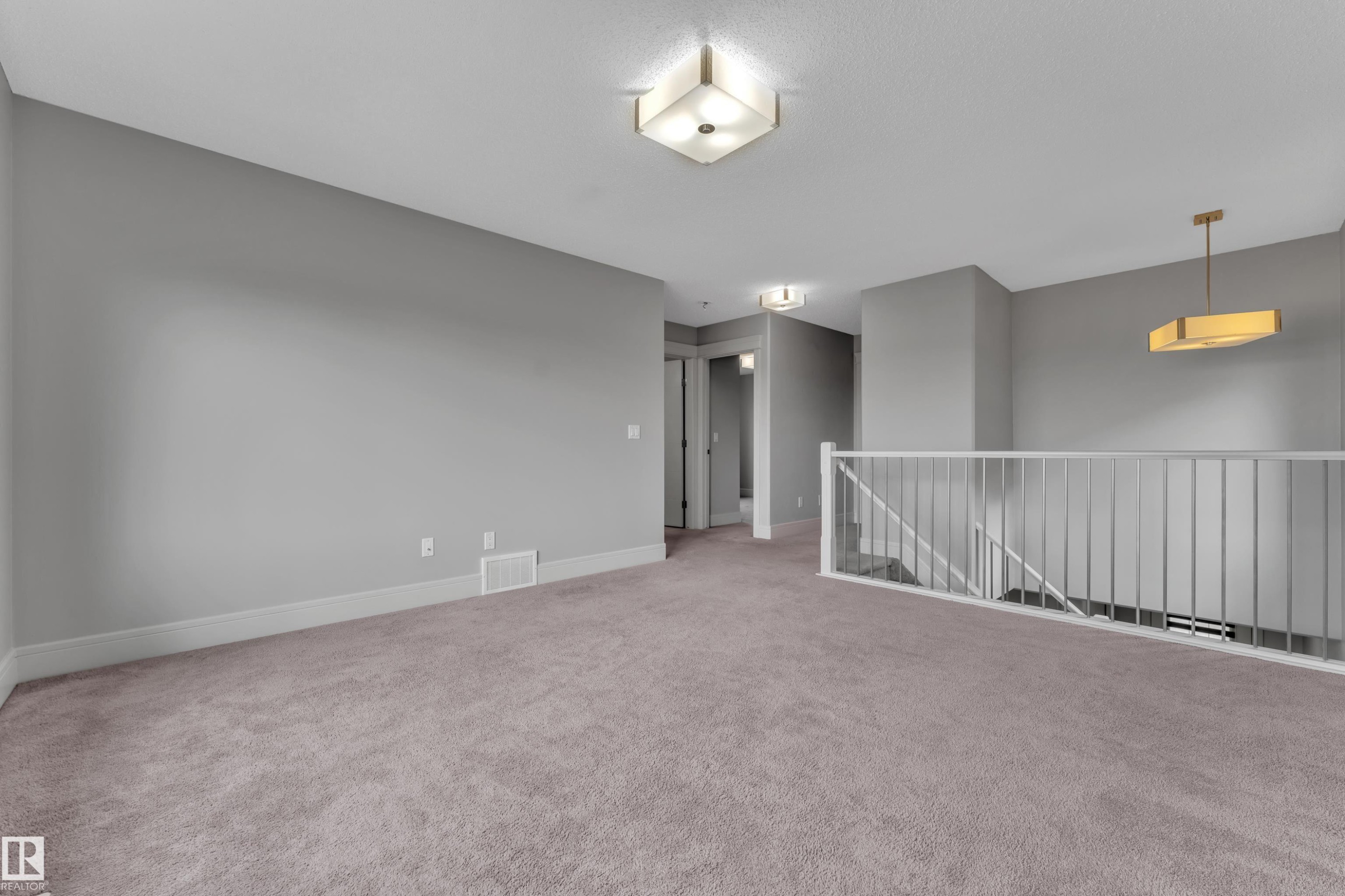 Expansive carpeted area with neutral gray walls and white trim - 3363 13 Ave, Edmonton, AB