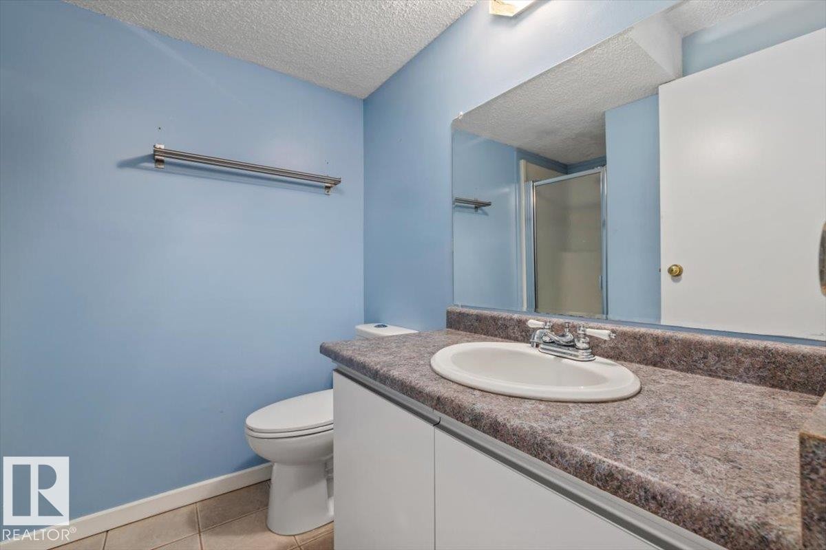 Bathroom featuring a vanity with an integrated sink, laminate countertop, and chrome faucet - 8103 154 Avenue, Edmonton, AB