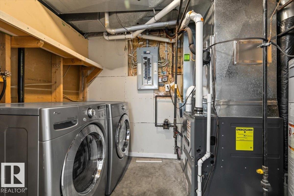 Dedicated utility area featuring a concrete floor, exposed ceiling pipes, and a wood-framed shelf - 8103 154 Avenue, Edmonton, AB