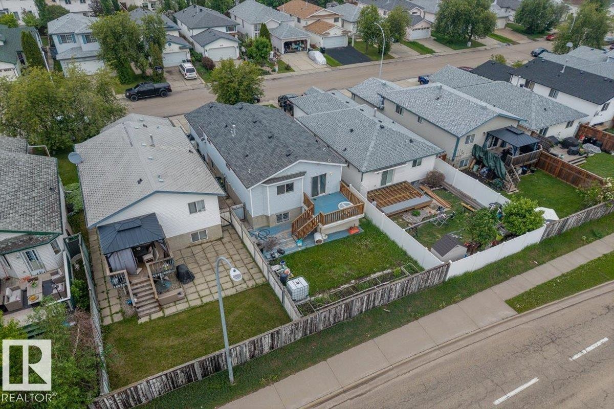 Rear exterior featuring a spacious wooden deck with a gazebo, a concrete patio, and a grassed area - 8103 154 Avenue, Edmonton, AB
