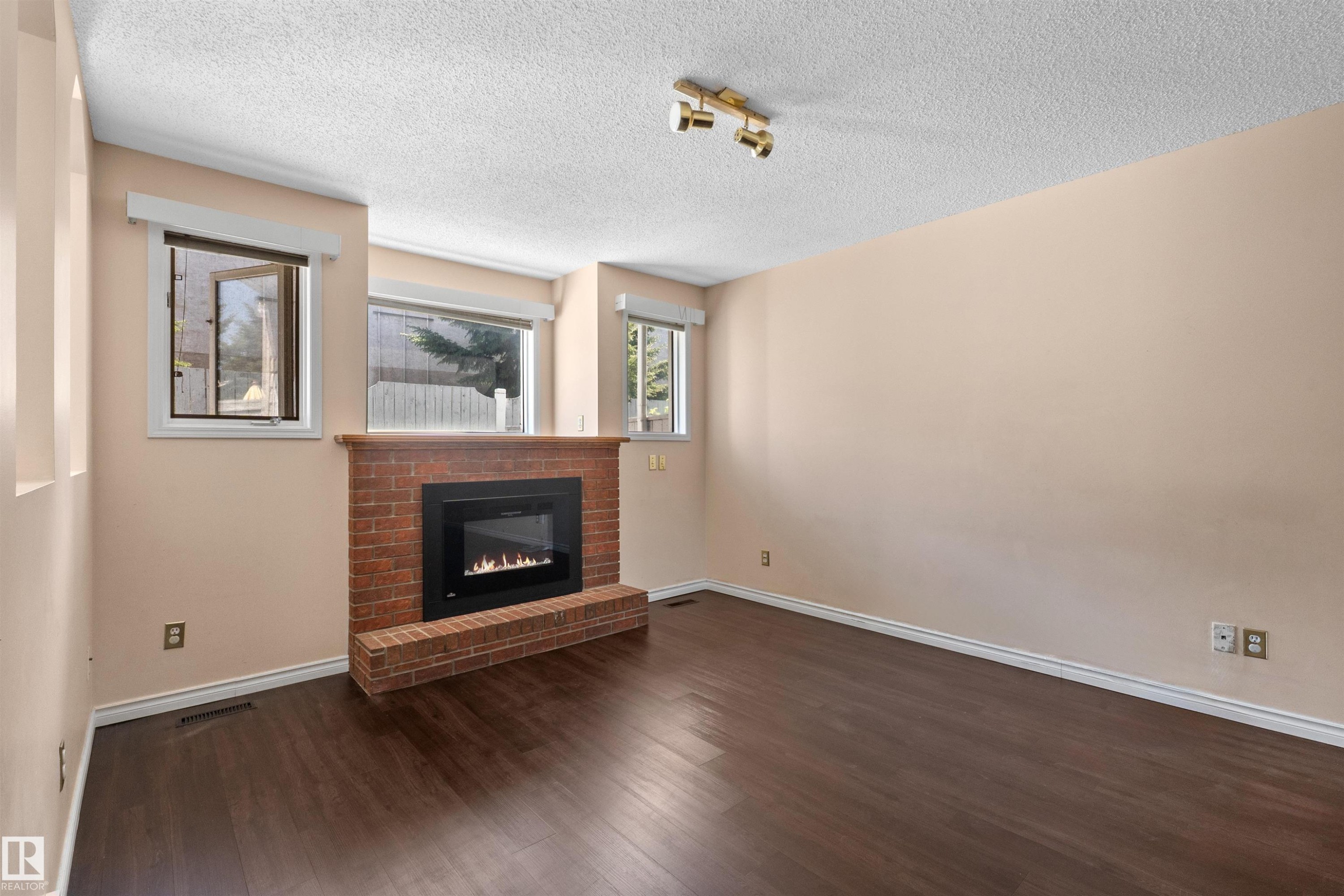 Brick fireplace with a gas insert and a wood mantle - 5 20 Deerbourne Drive, St. Albert, AB