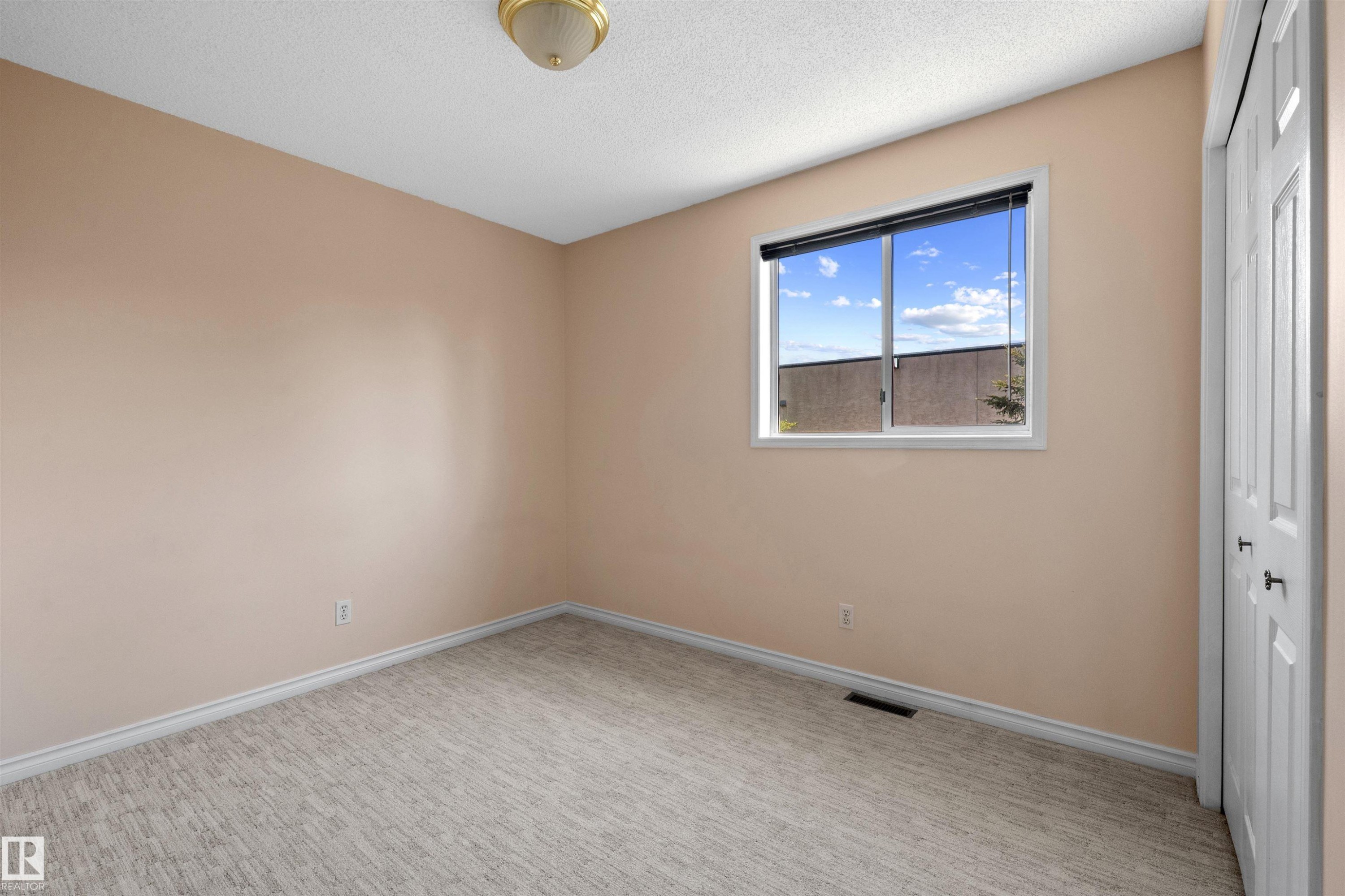 Bedroom featuring light-toned walls and pattern carpeting - 5 20 Deerbourne Drive, St. Albert, AB