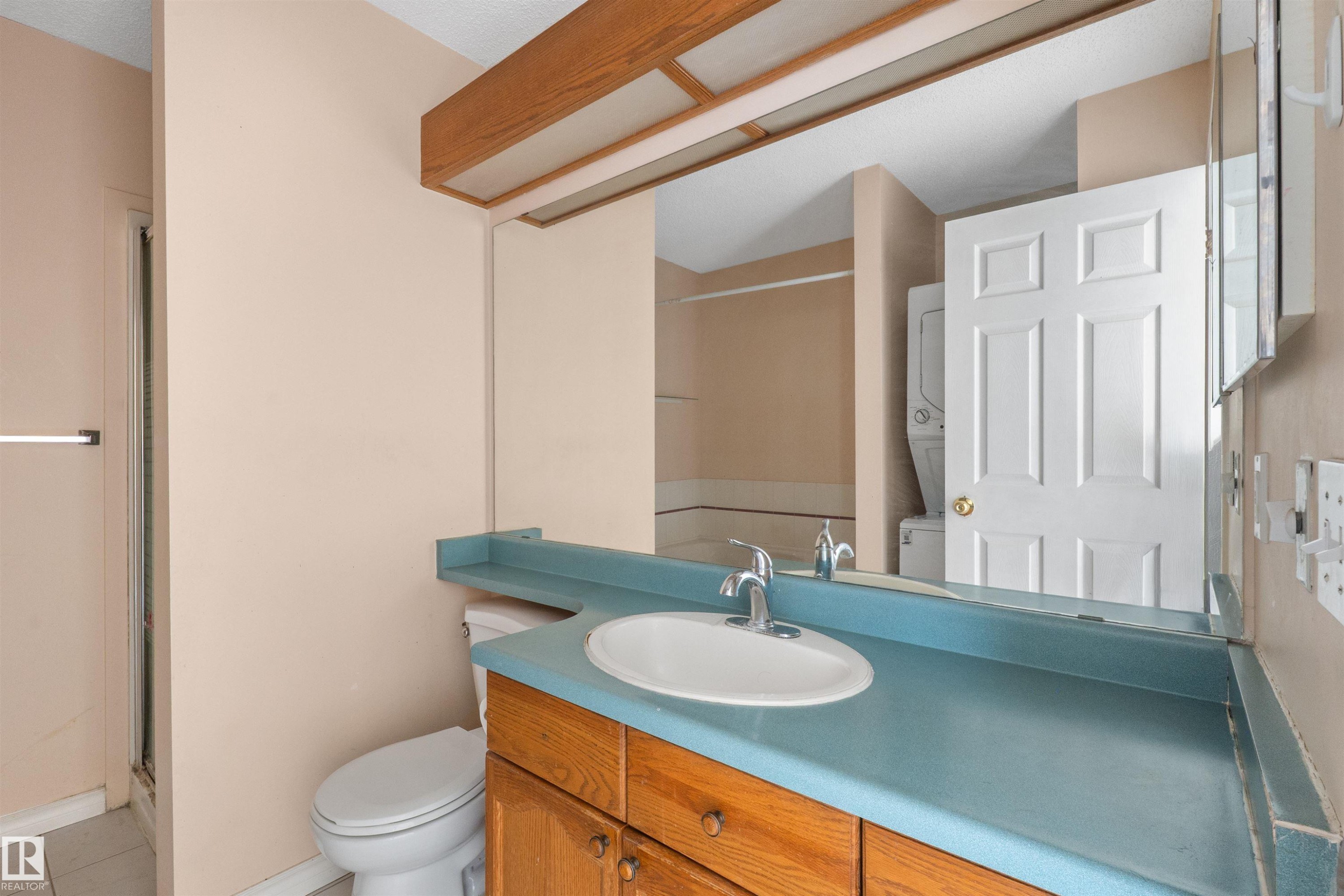 Bathroom vanity featuring a light blue countertop with an integrated sink and chrome faucet - 5 20 Deerbourne Drive, St. Albert, AB