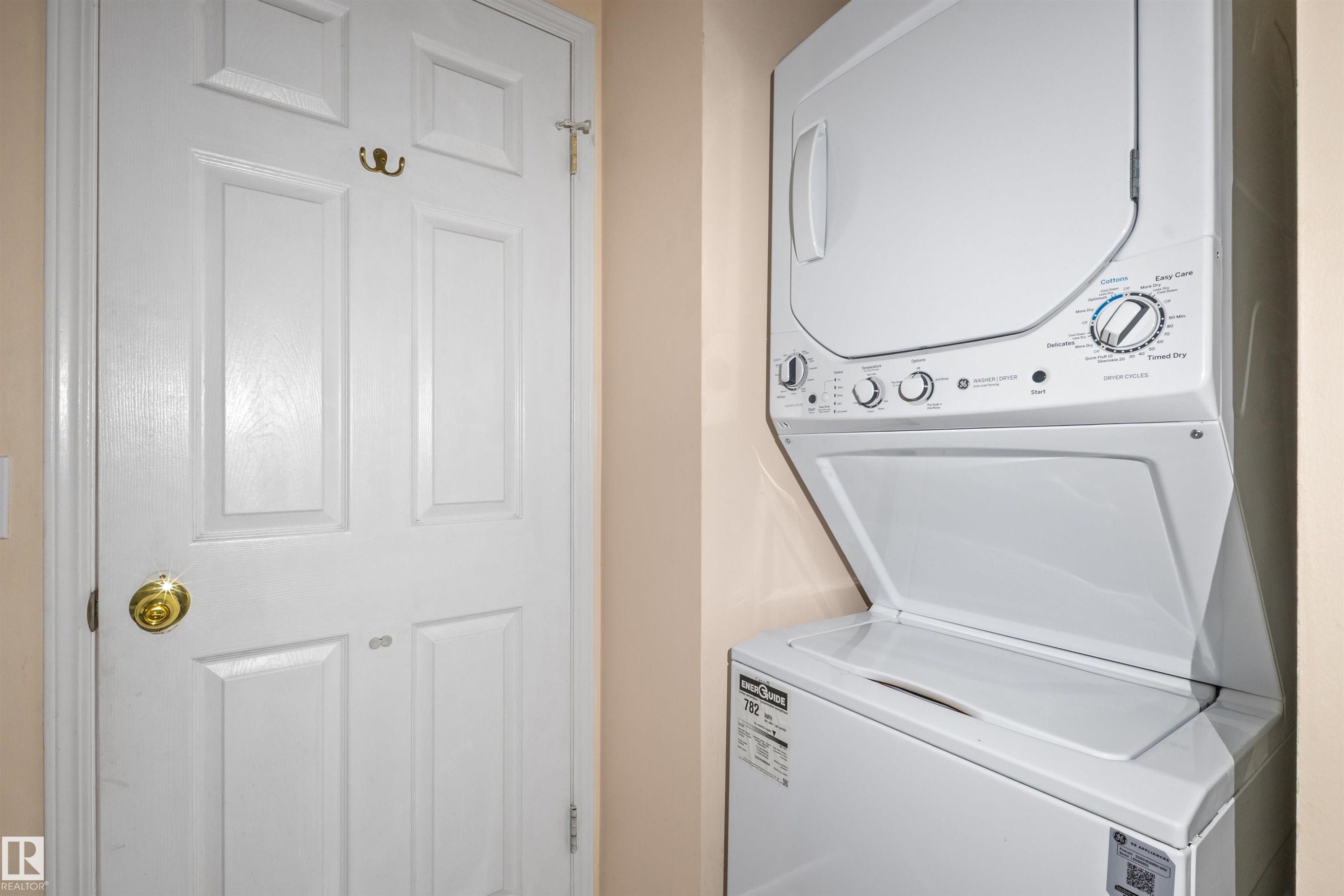 Included stacked laundry appliances with white finishes, featuring a top-loading washer and front-loading dryer - 5 20 Deerbourne Drive, St. Albert, AB