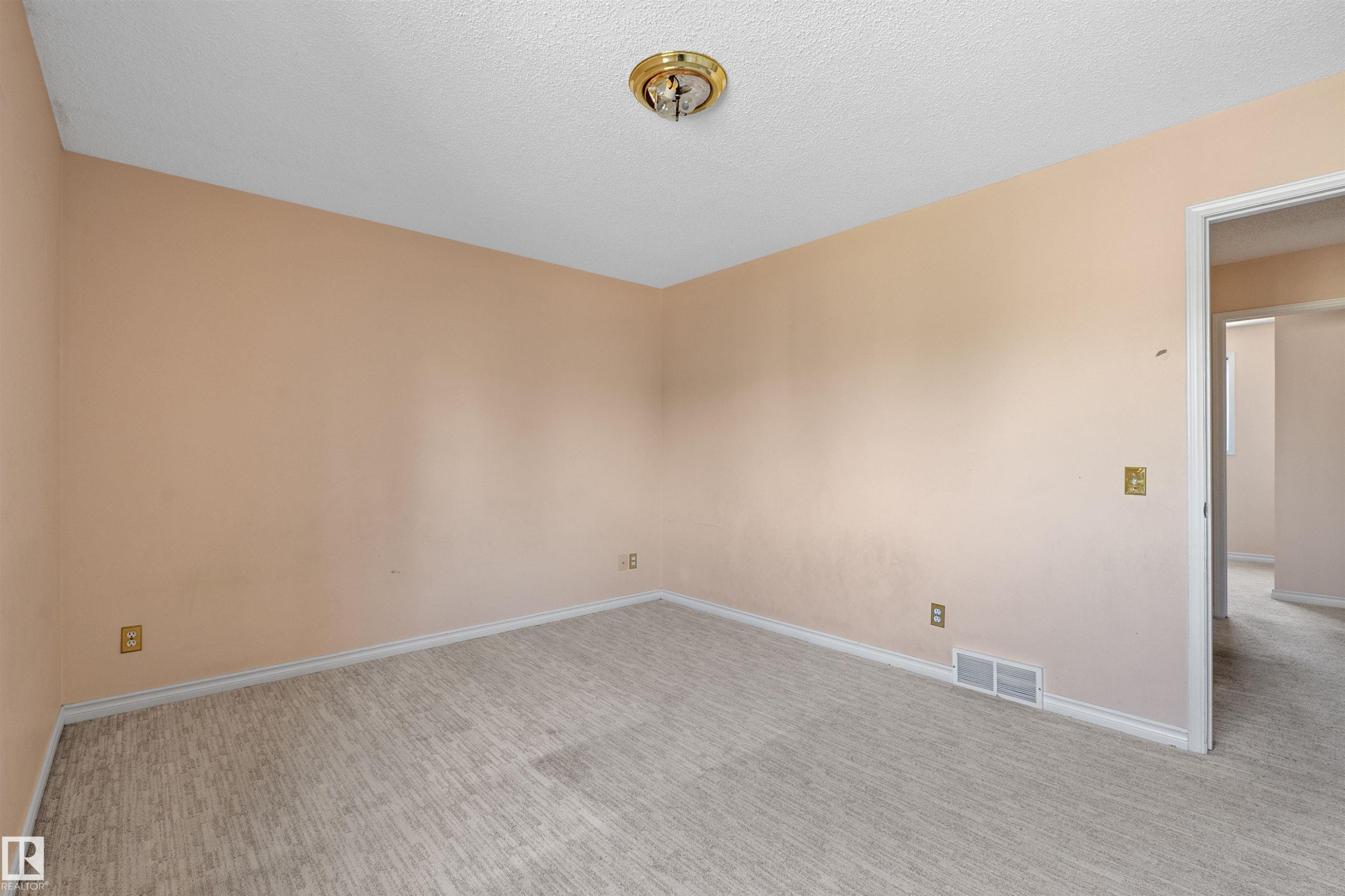Neutral-toned carpeting spans the floor, complemented by light-colored walls and white baseboards - 5 20 Deerbourne Drive, St. Albert, AB
