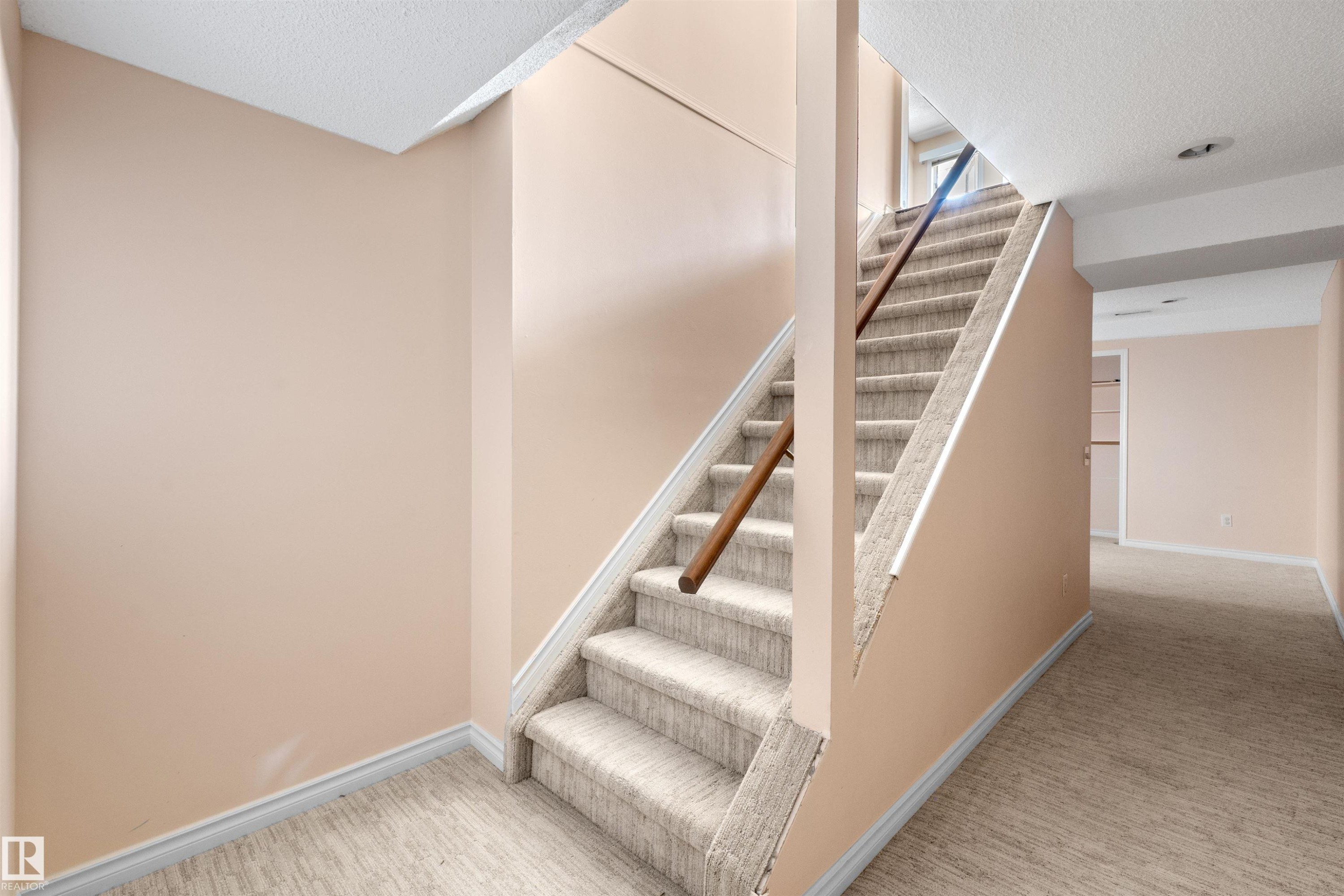 Carpeted staircase with wooden handrail, leading to an upper level - 5 20 Deerbourne Drive, St. Albert, AB