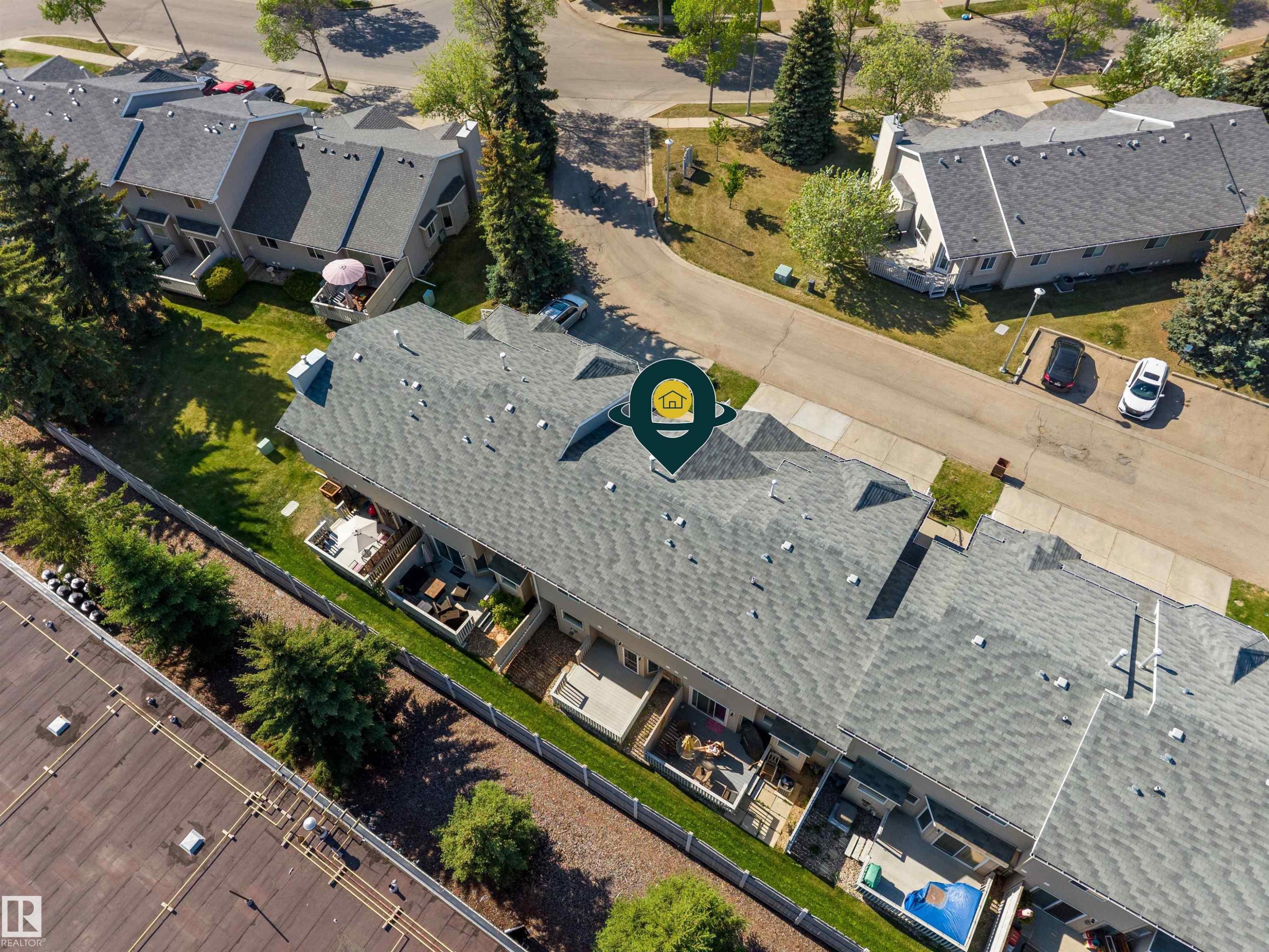 Townhome exterior featuring a gabled roofline and individual rear patios - 5 20 Deerbourne Drive, St. Albert, AB
