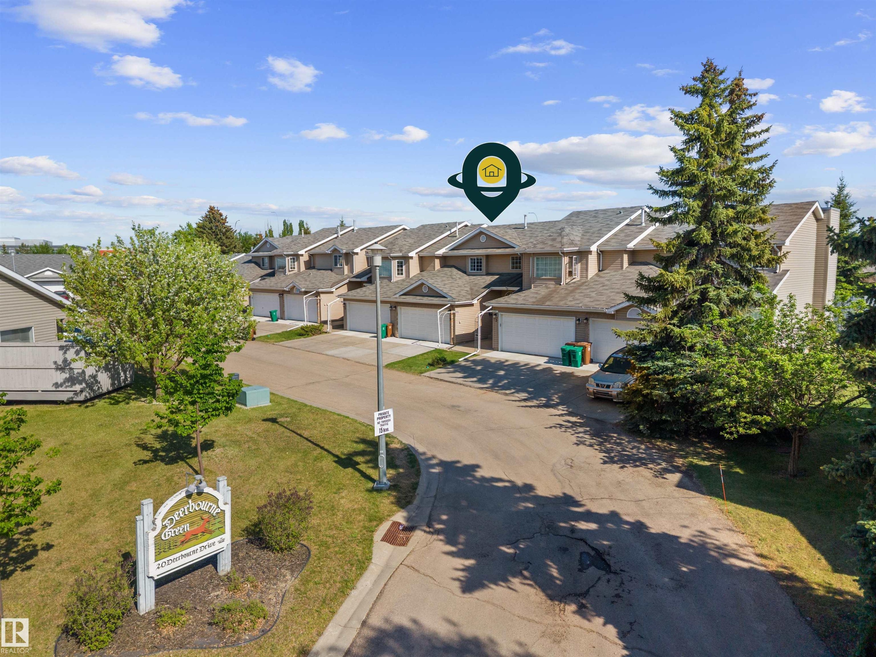 Townhouse exterior featuring an attached garage and individual entry - 5 20 Deerbourne Drive, St. Albert, AB
