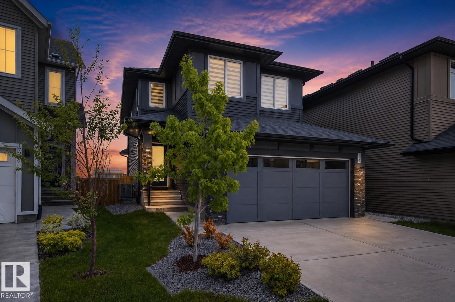 Modern facade with dark siding and stone accents - 17023 45 Street, Edmonton, AB